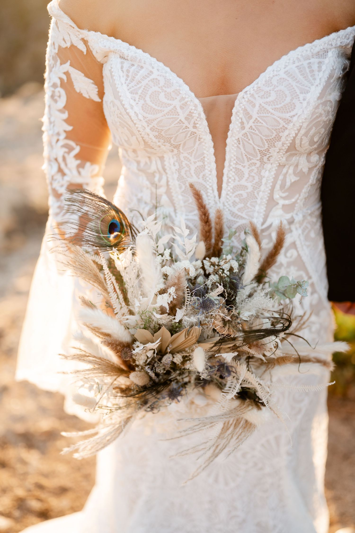 Detailed shot of wedding dress bodice adorned with delicate dried flowers and lace details.