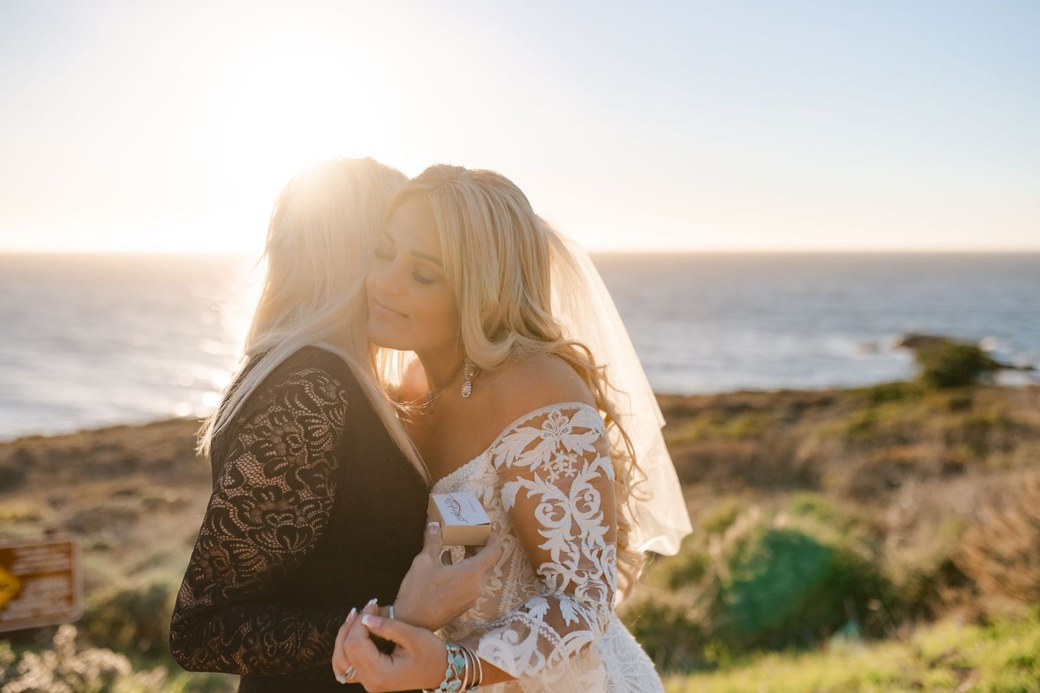 A tender wedding moment captured at sunset by the ocean.