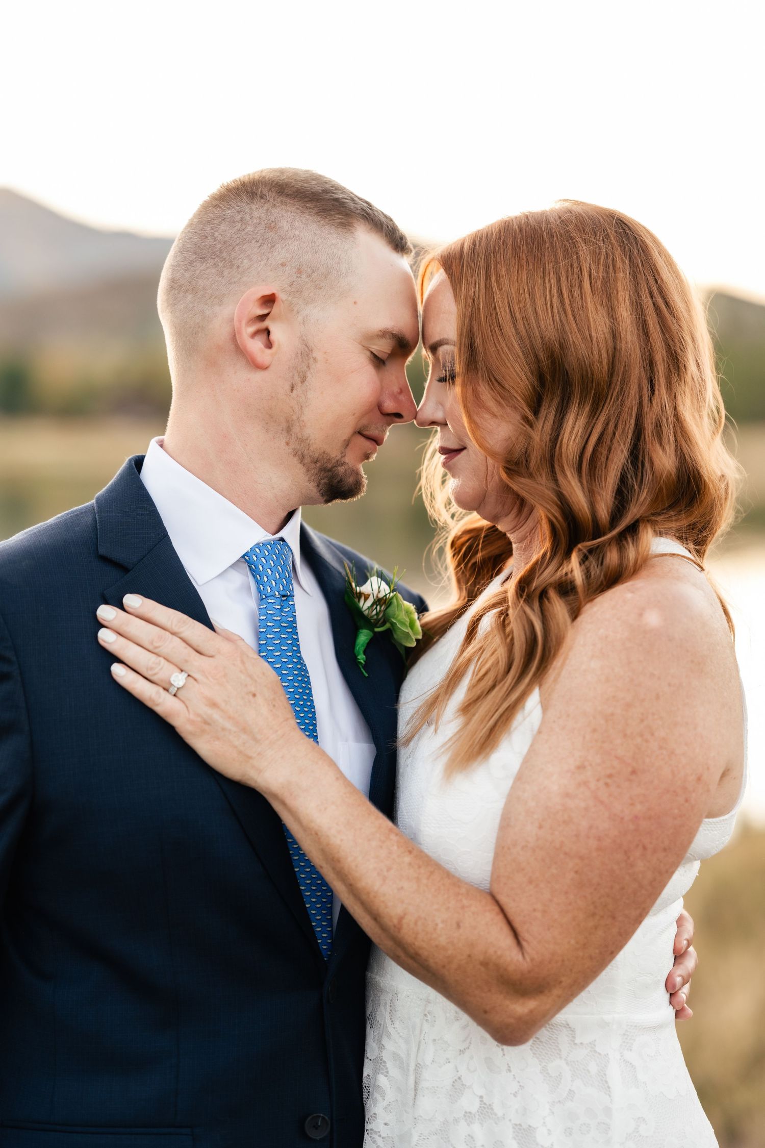 Intimate wedding portraits captured in golden light with a scenic mountain landscape.