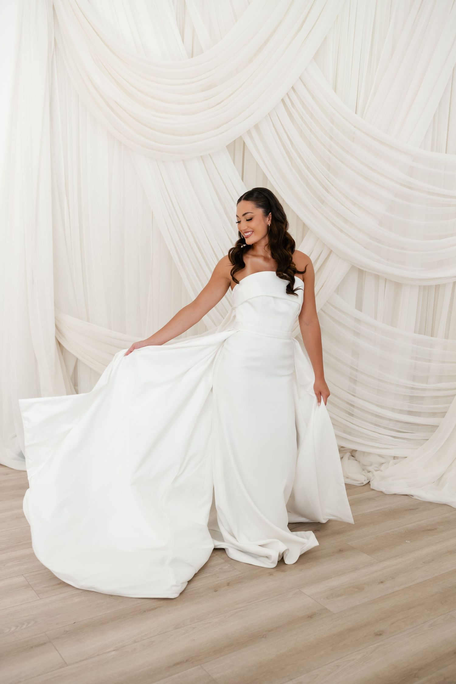 Bride dances in her dress at Moments on Main by elegant draping by Utah Wedding Photographer and Videographer. Utah Wedding Venue.