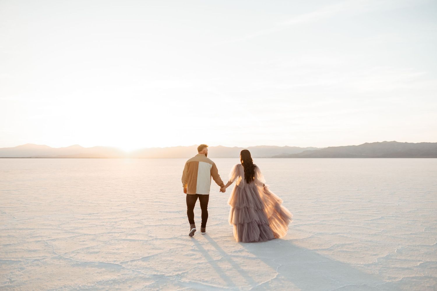 Couple holds hands during golden hour at the Salt Flats by Utah Salt Flats photographer