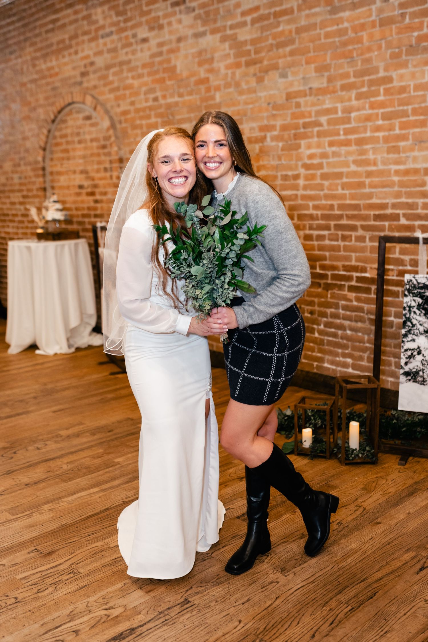 A wedding celebration in a rustic brick venue with hardwood floors and green decorative elements.