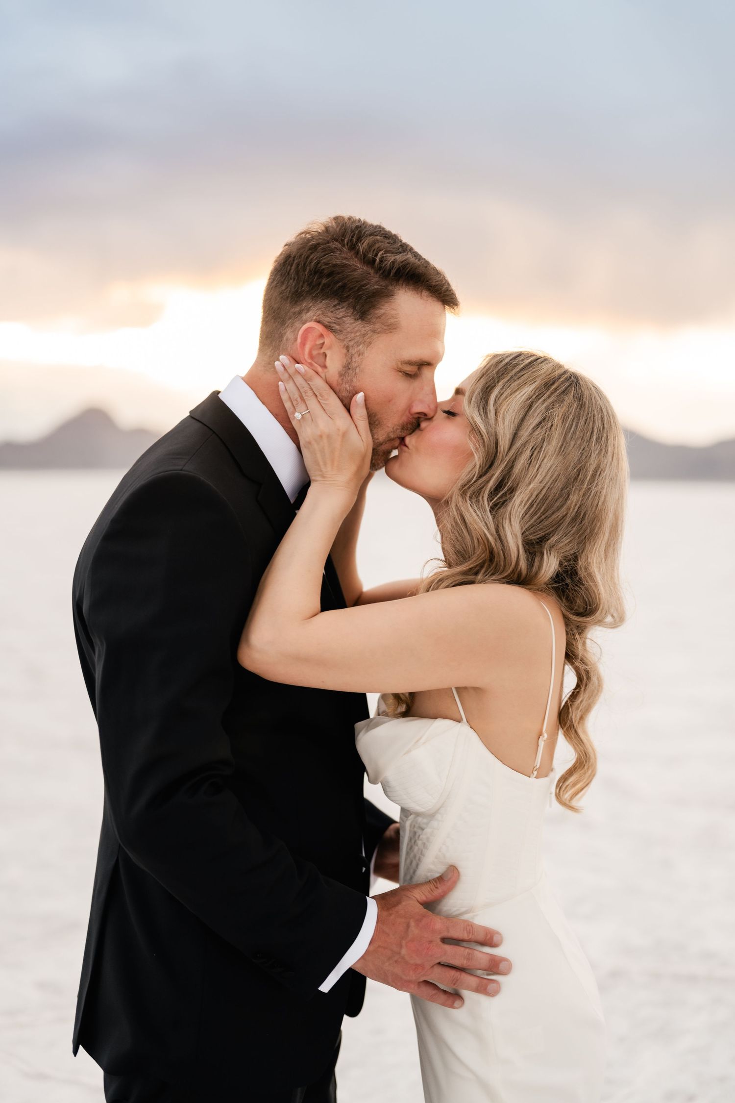 Salt Flats Elopement Photographer. A romantic wedding kiss captured at sunset with mountains in the background.