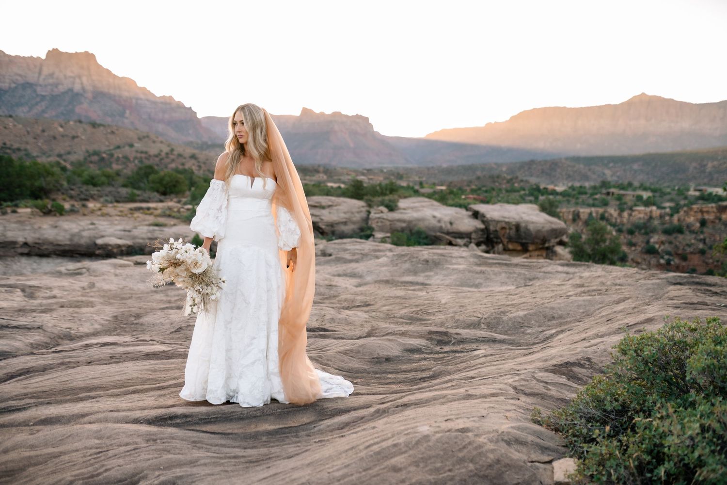 Zions wedding photographer takes beautiful desert sunrise bridals featuring a unique veil and dried floral bouquet.