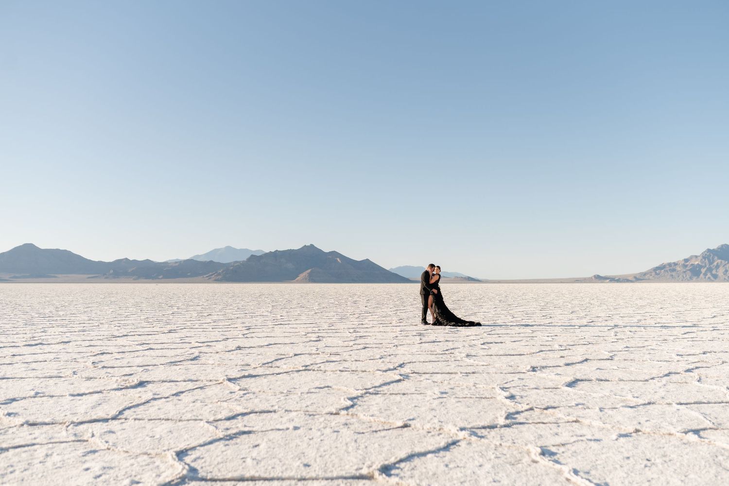 Salt Flats Photographer. A figure stands alone on the vast white expanse of the Bonneville Salt Flats with mountains in the distance.