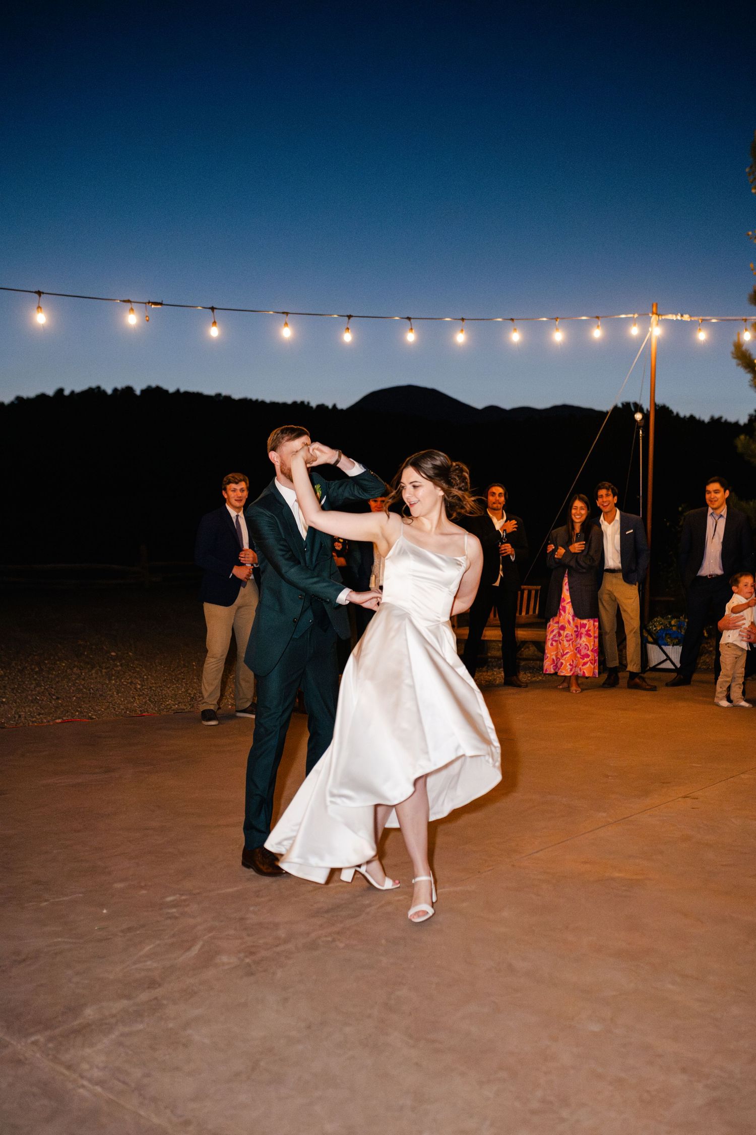 Evening outdoor dance celebration with string lights creating a romantic ambiance.