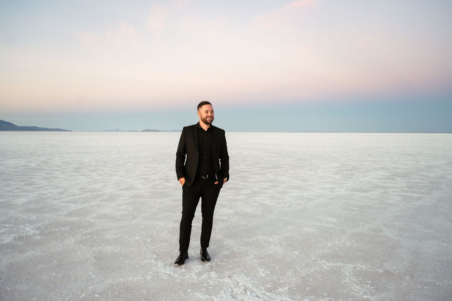 Minimalist landscape shots of salt flats with distant figures and mountains.