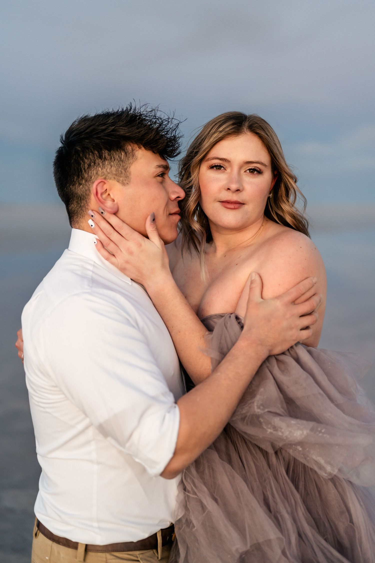 A tender embrace between the couple, illuminated by the soft blue light of blue hour at the Salt Flats.