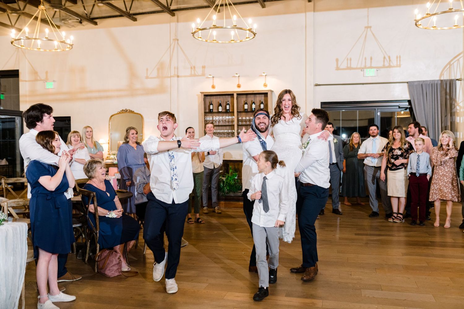 People dancing and celebrating at an elegant indoor wedding reception at The Wild Oak, a Utah County Wedding Venue.