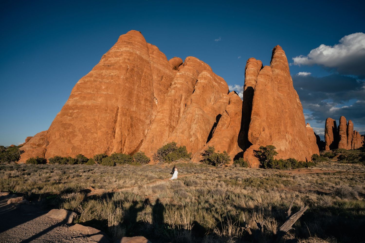 A series of red sandstone rock formations in Arches National Park against a deep blue desert sky.