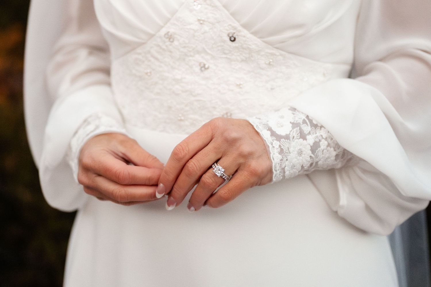 Close-up of lace details on white wedding dress sleeves.
