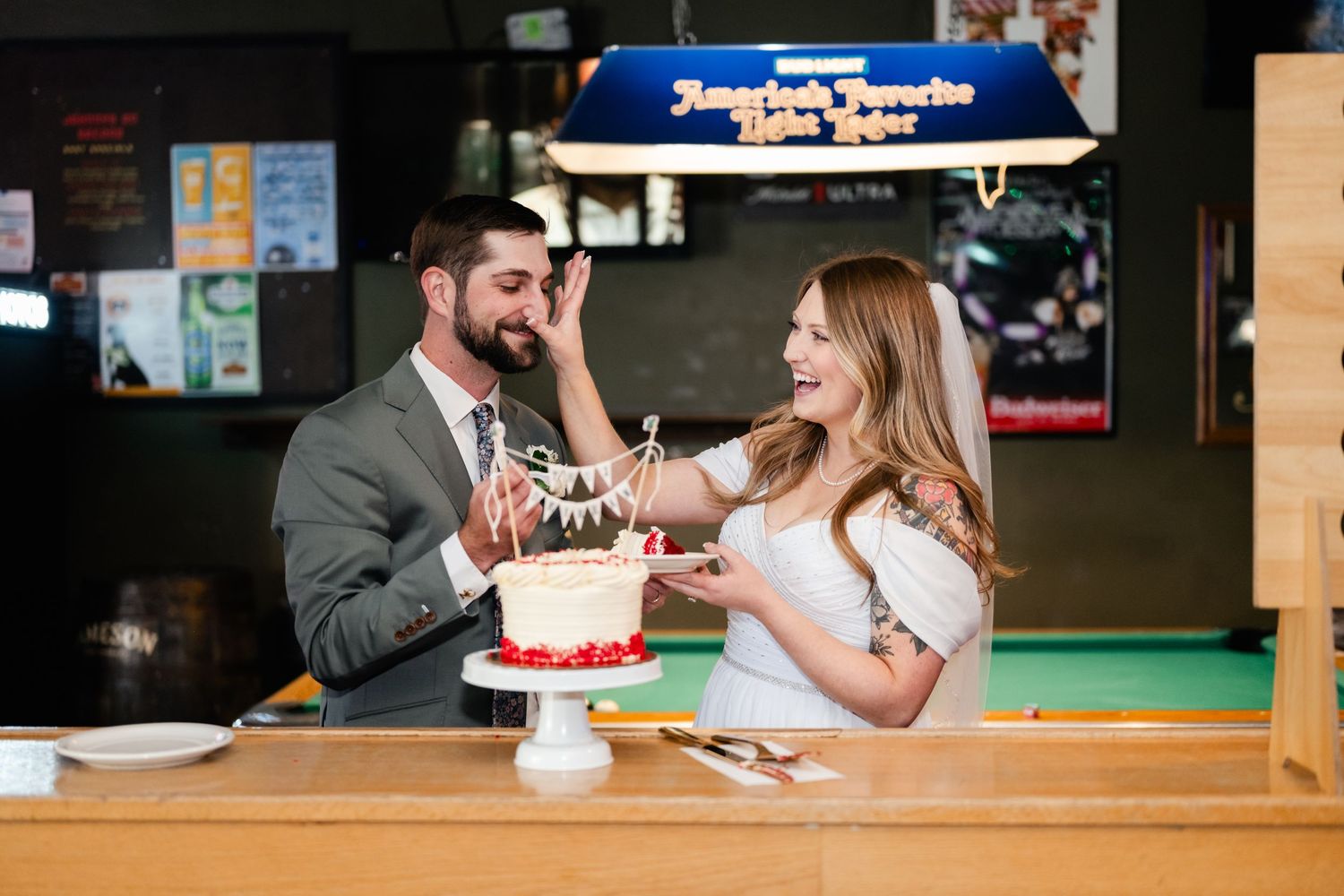 A couple sharing cake at a bar counter while celebrating together.
