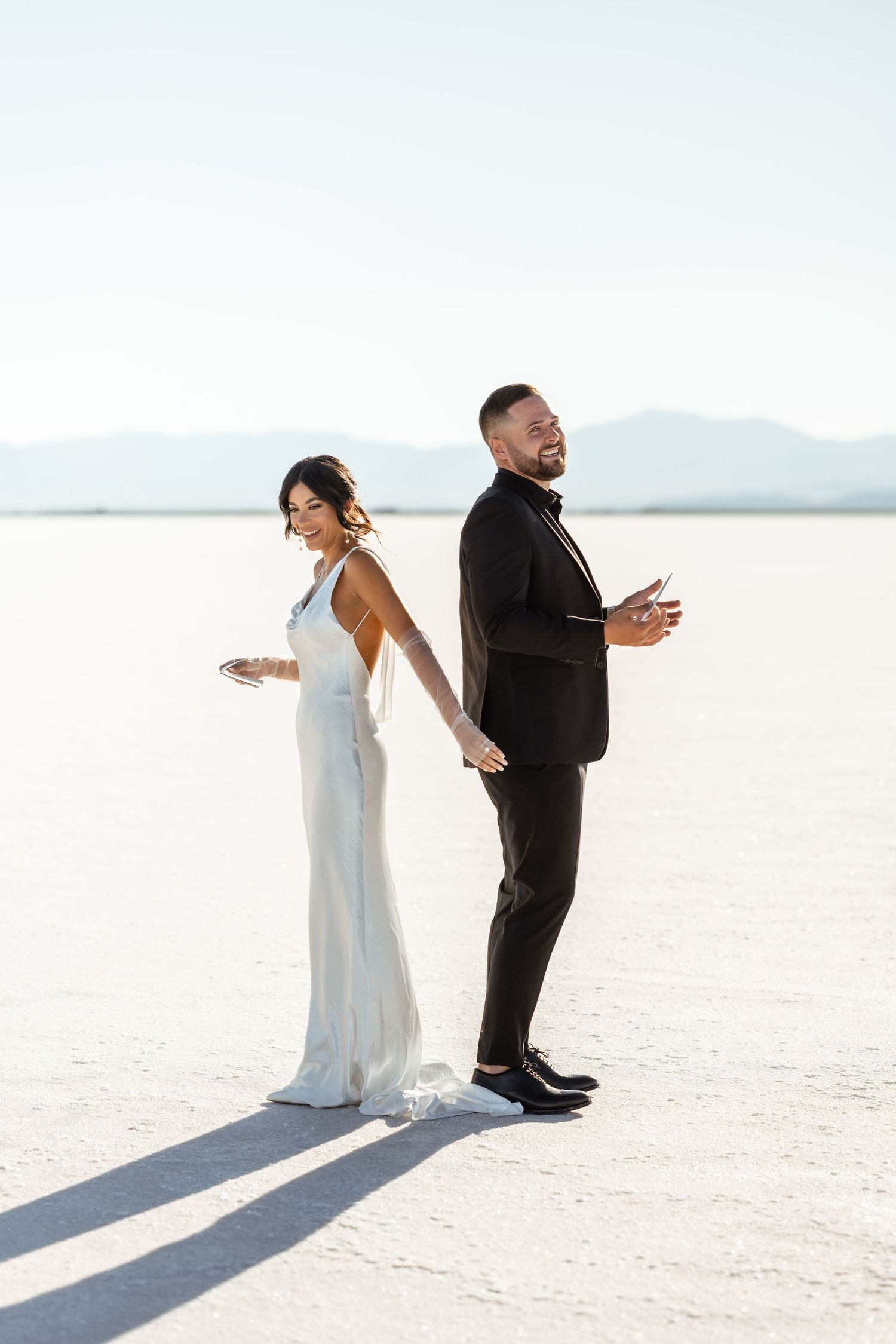 Joyful wedding couple sharing first look moment on scenic salt flats.