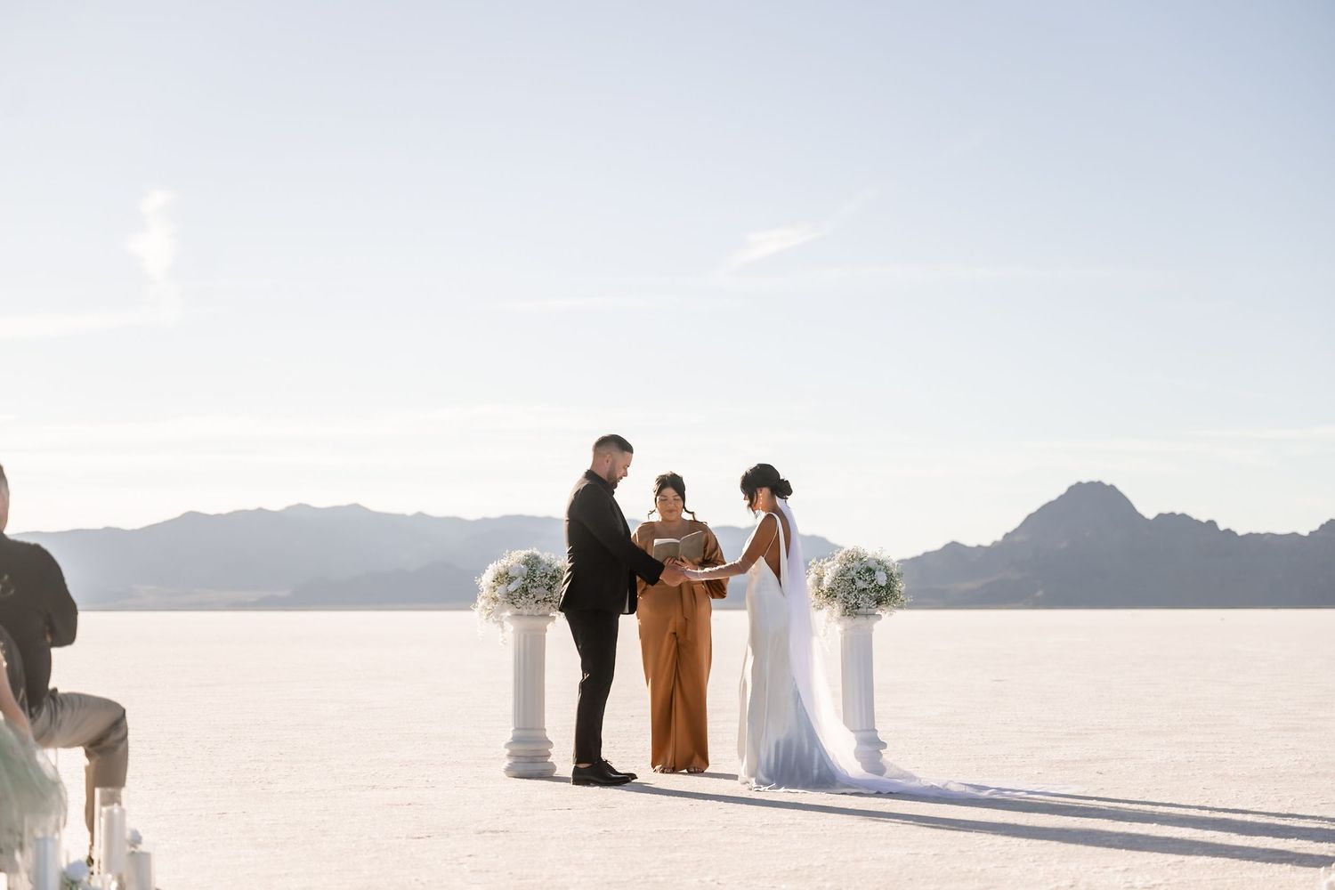 Wedding ceremony participants spread out across dramatic salt flat landscape.