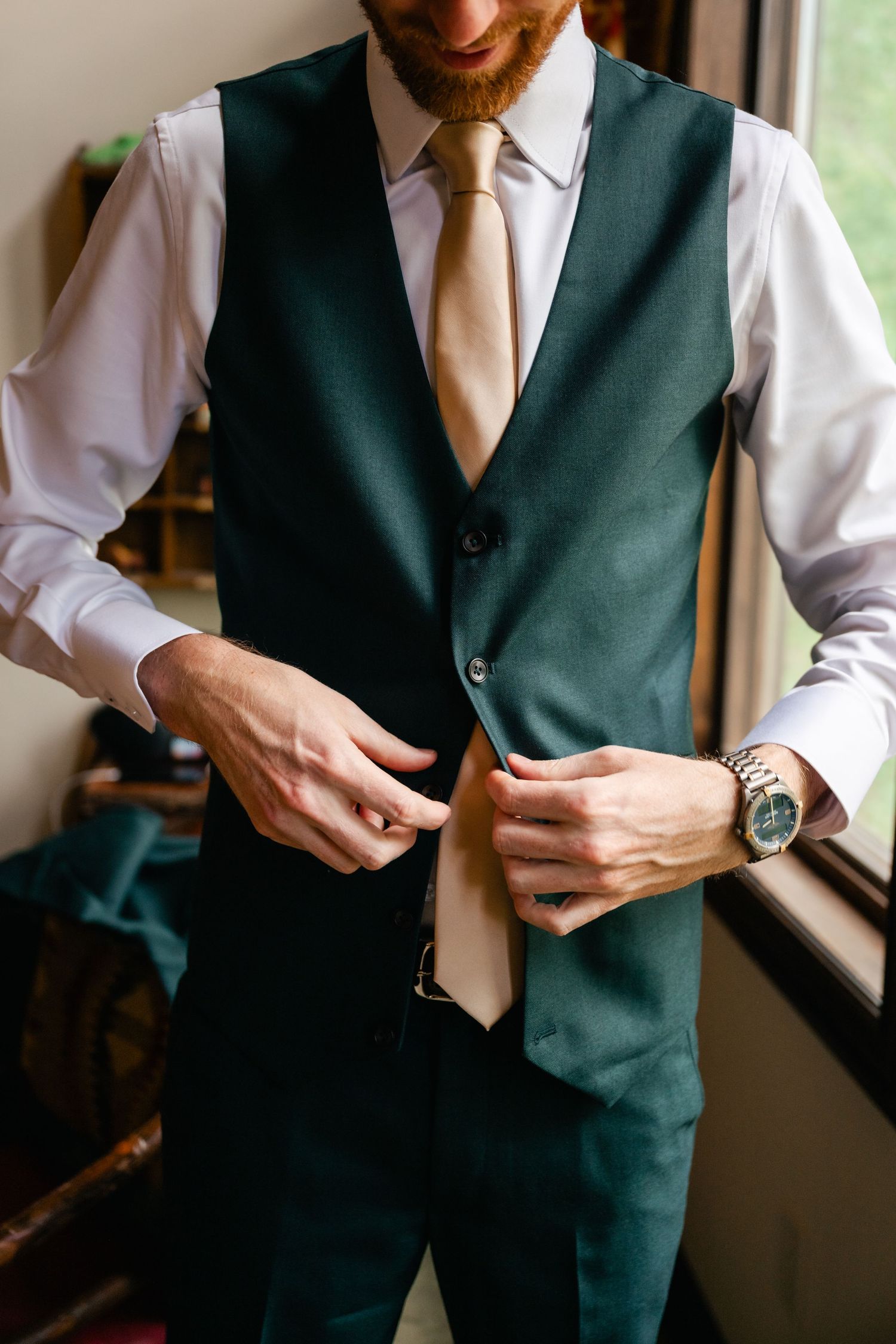Close-up shots of a person in dark green vest and white shirt adjusting formal attire.
