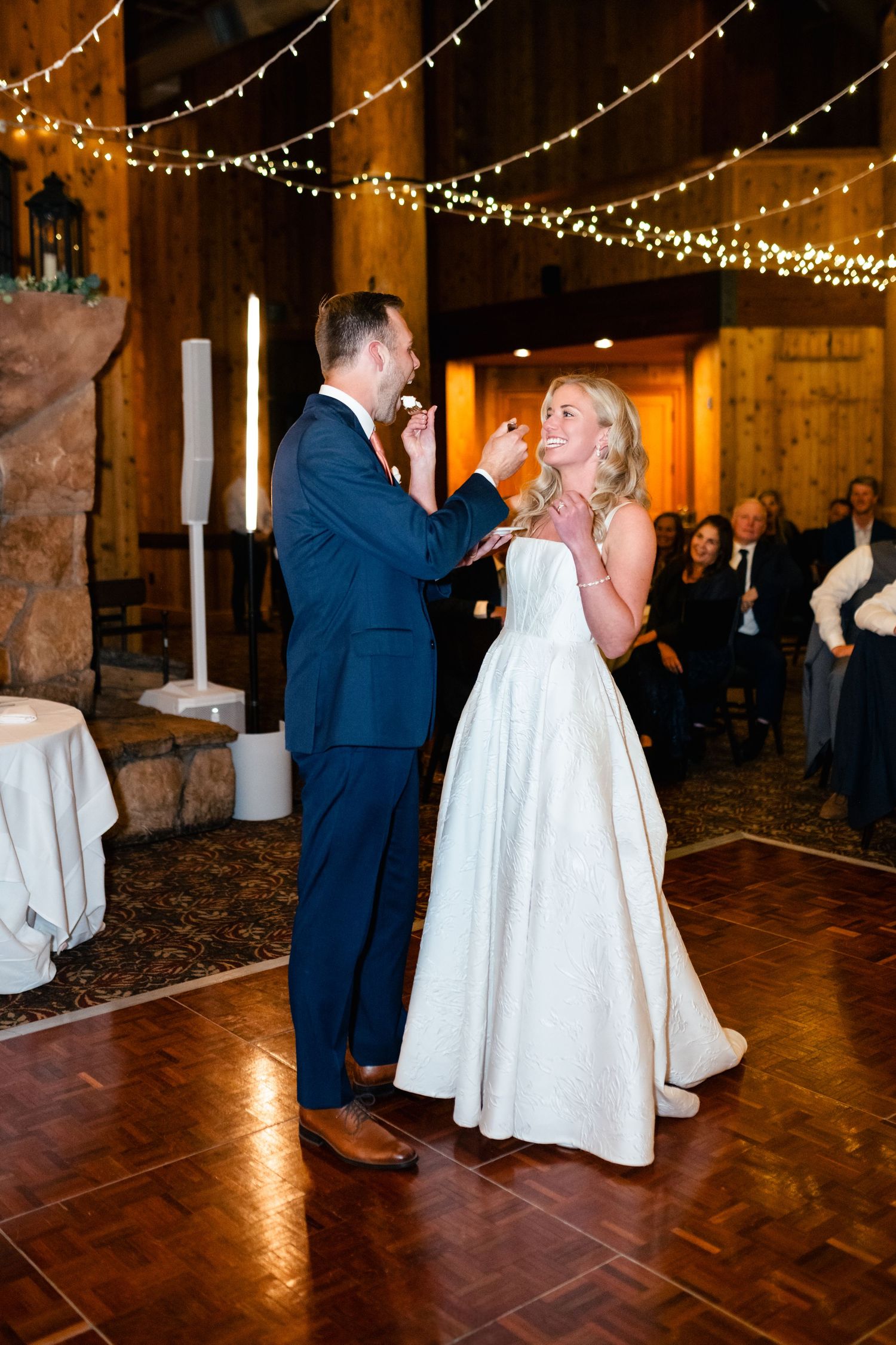 Couple shares their first dance under twinkling lights in a rustic barn venue.