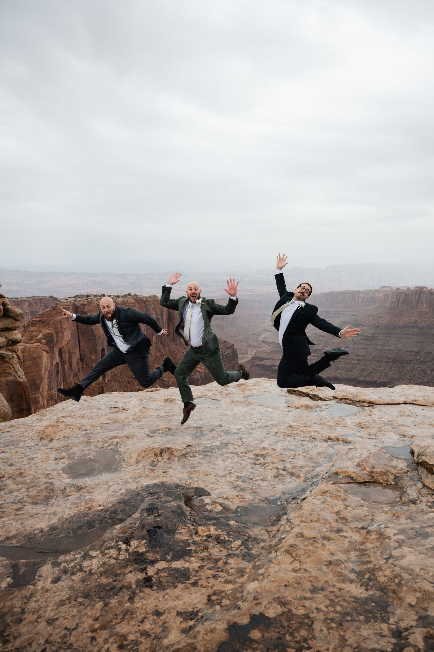 A sequence of playful jumping poses captured on a scenic desert cliff edge with dramatic canyon views.