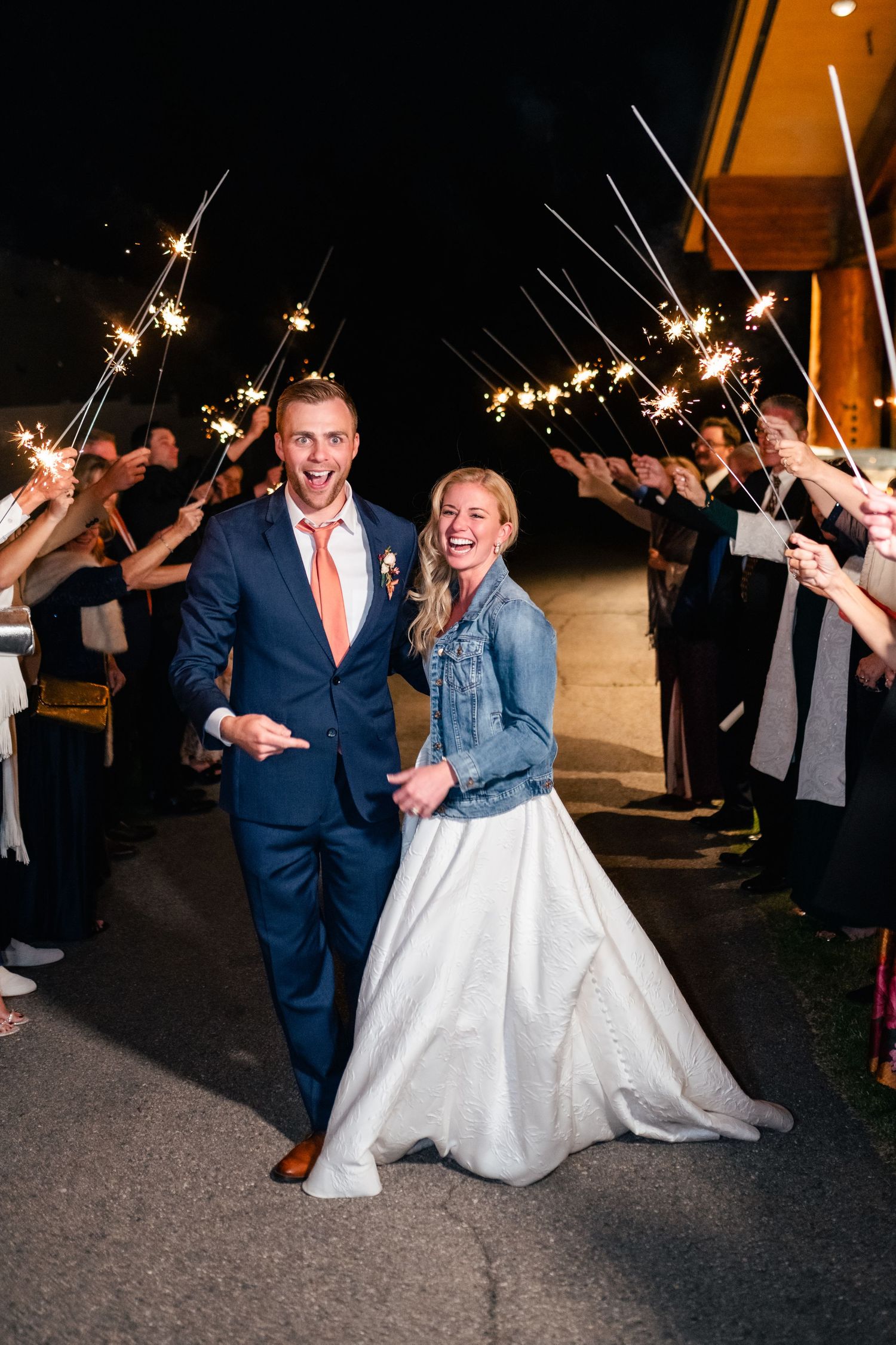 A sparkler exit for a couple in formal attire walking through a crowd of wedding guests. Utah Wedding Photographer. Park City Wedding.