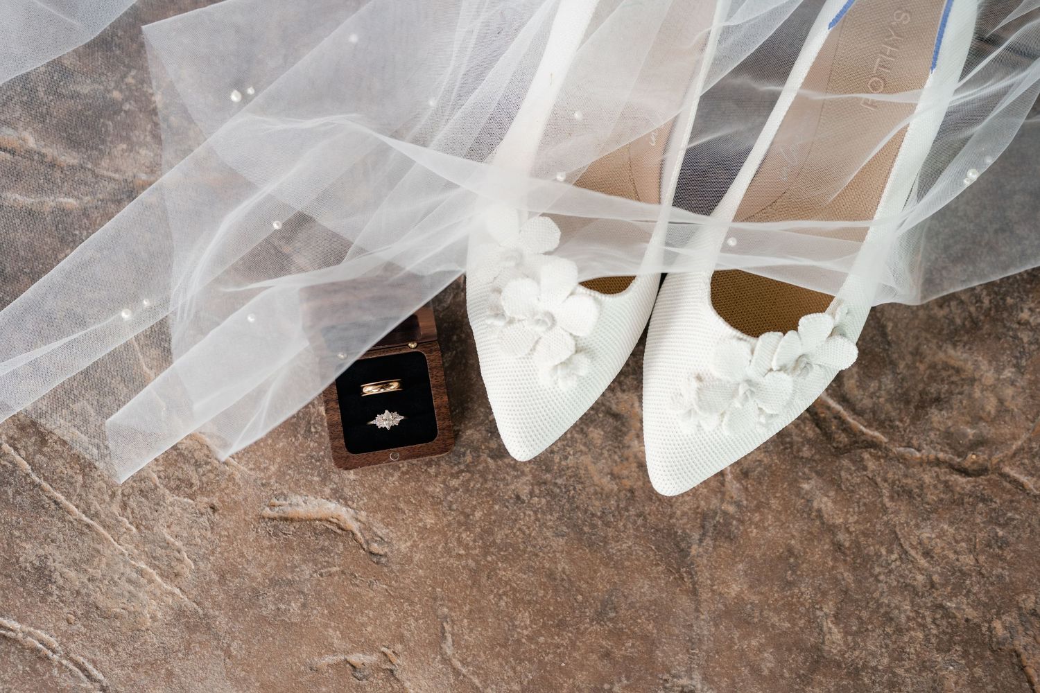 Detail shots of white tulle wedding veil fabric draped across a textured brown surface.
