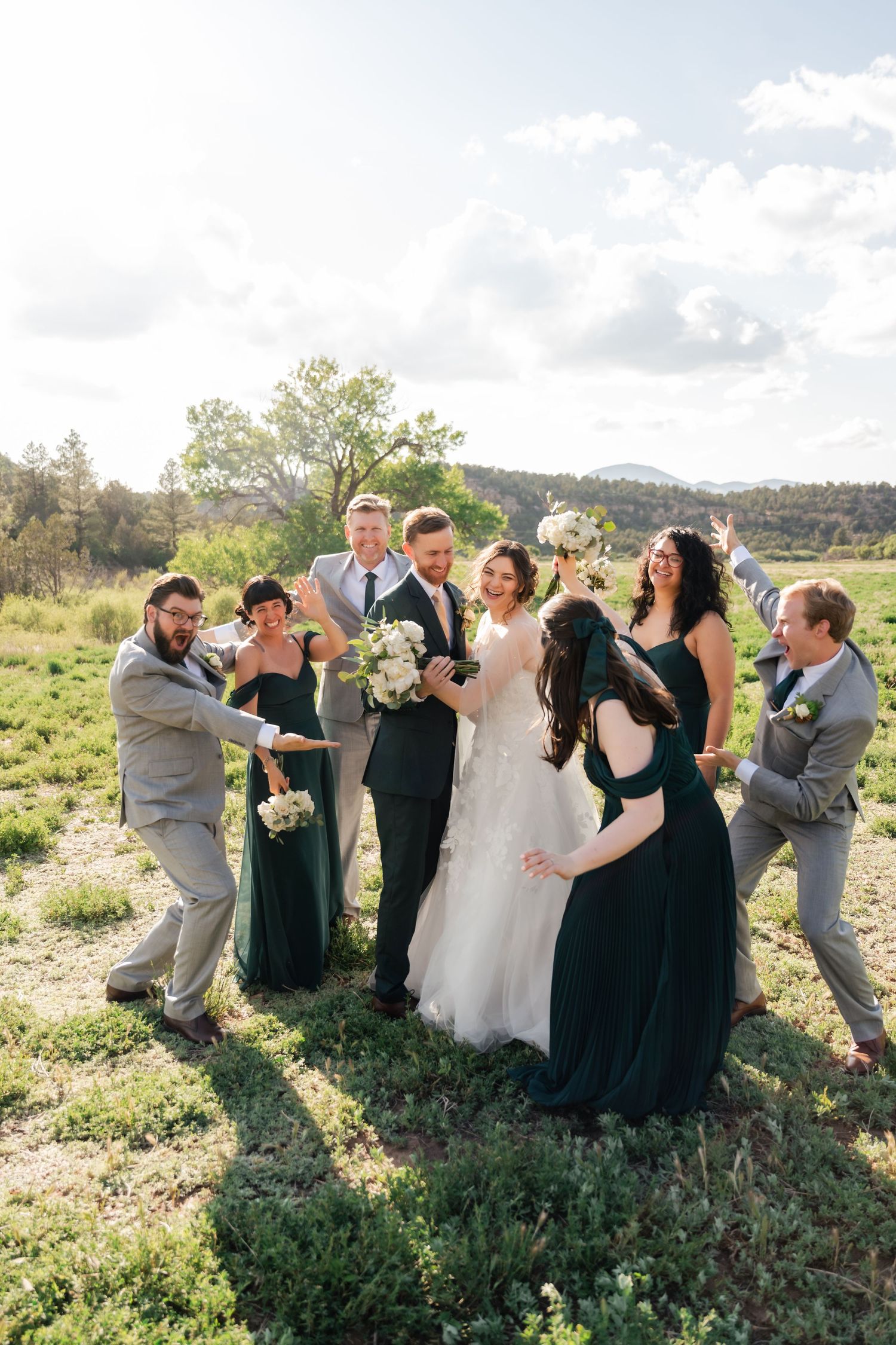 Wedding party poses playfully in a sequence of candid shots outdoors in a sunny field with natural greenery.