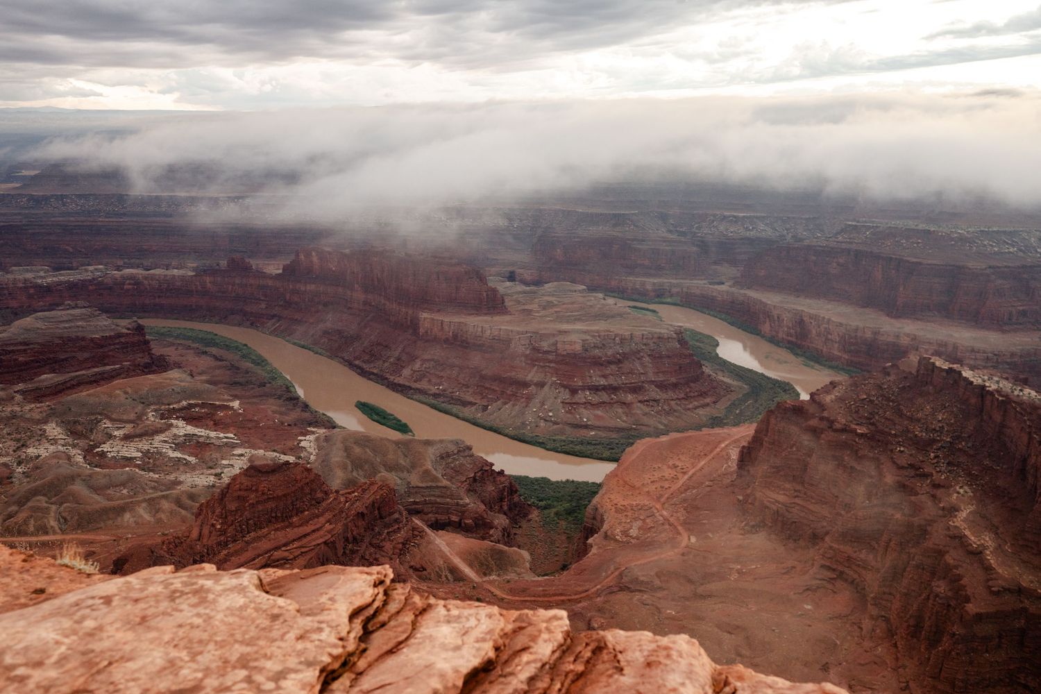 Panoramic aerial view of Dead Horse Point State Park in Utah showcasing dramatic red rock canyons and winding river below.