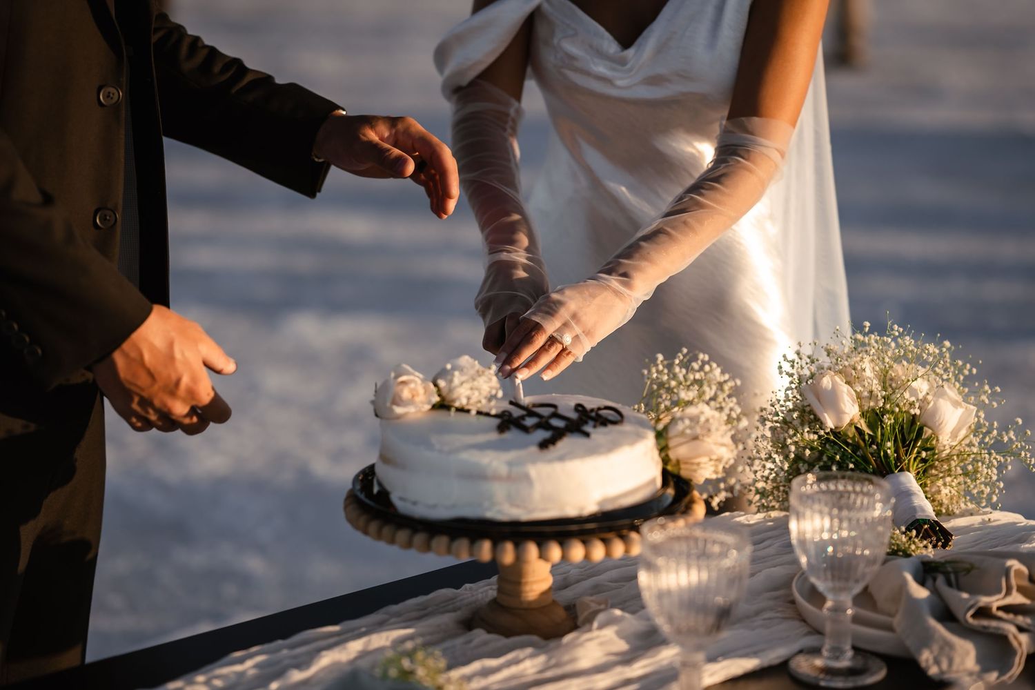Close-up details of table settings and decor on a white surface with glassware and floral elements.