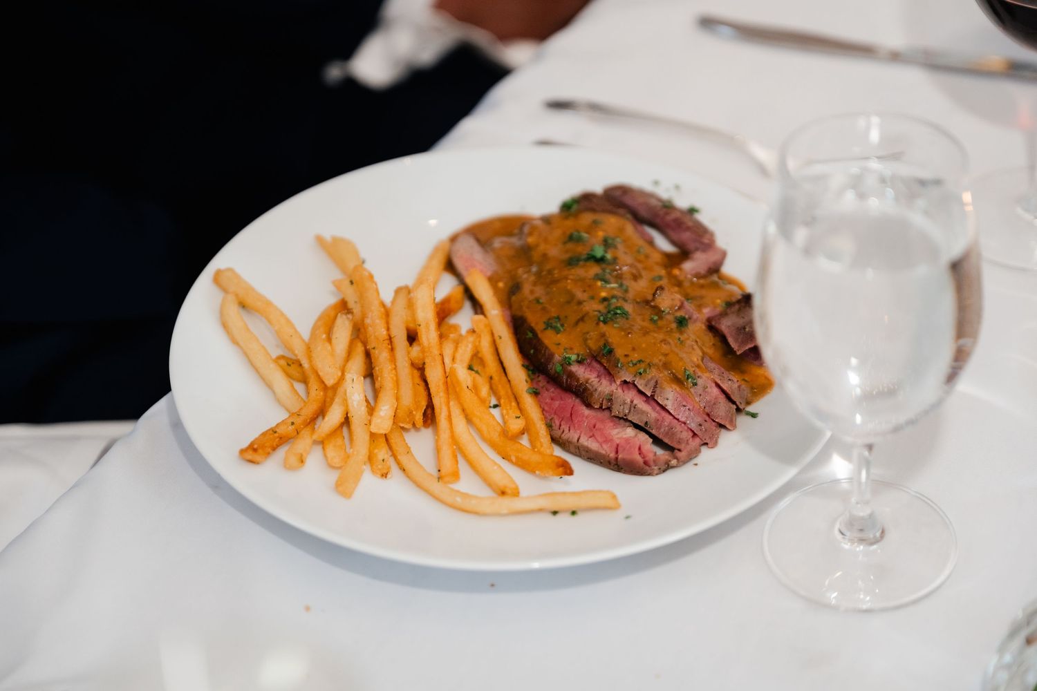 Plated dinner with french fries and steak served at an elegant wedding reception.