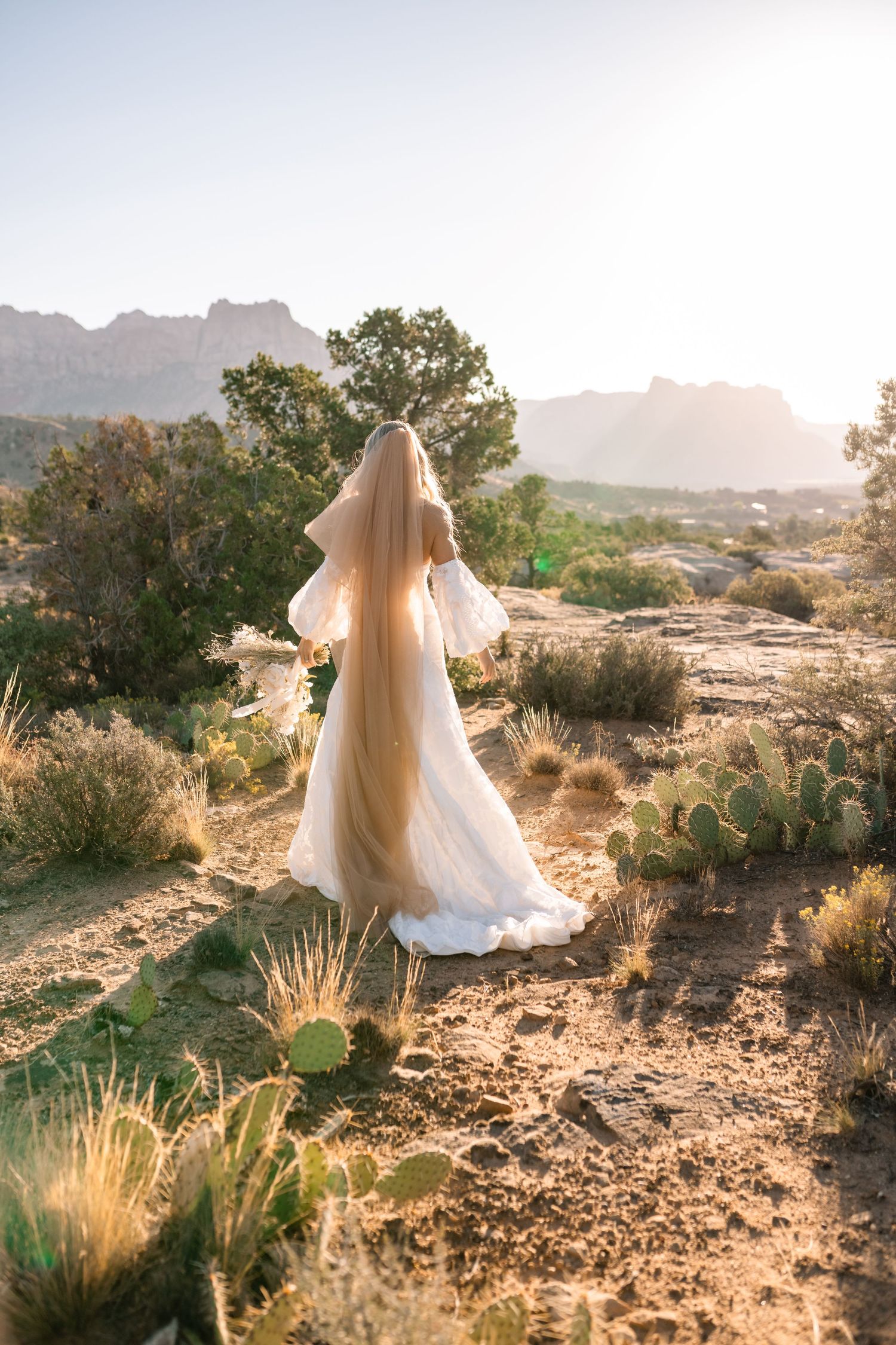 Zions wedding photographer takes beautiful desert sunrise bridals featuring a unique veil and dried floral bouquet.