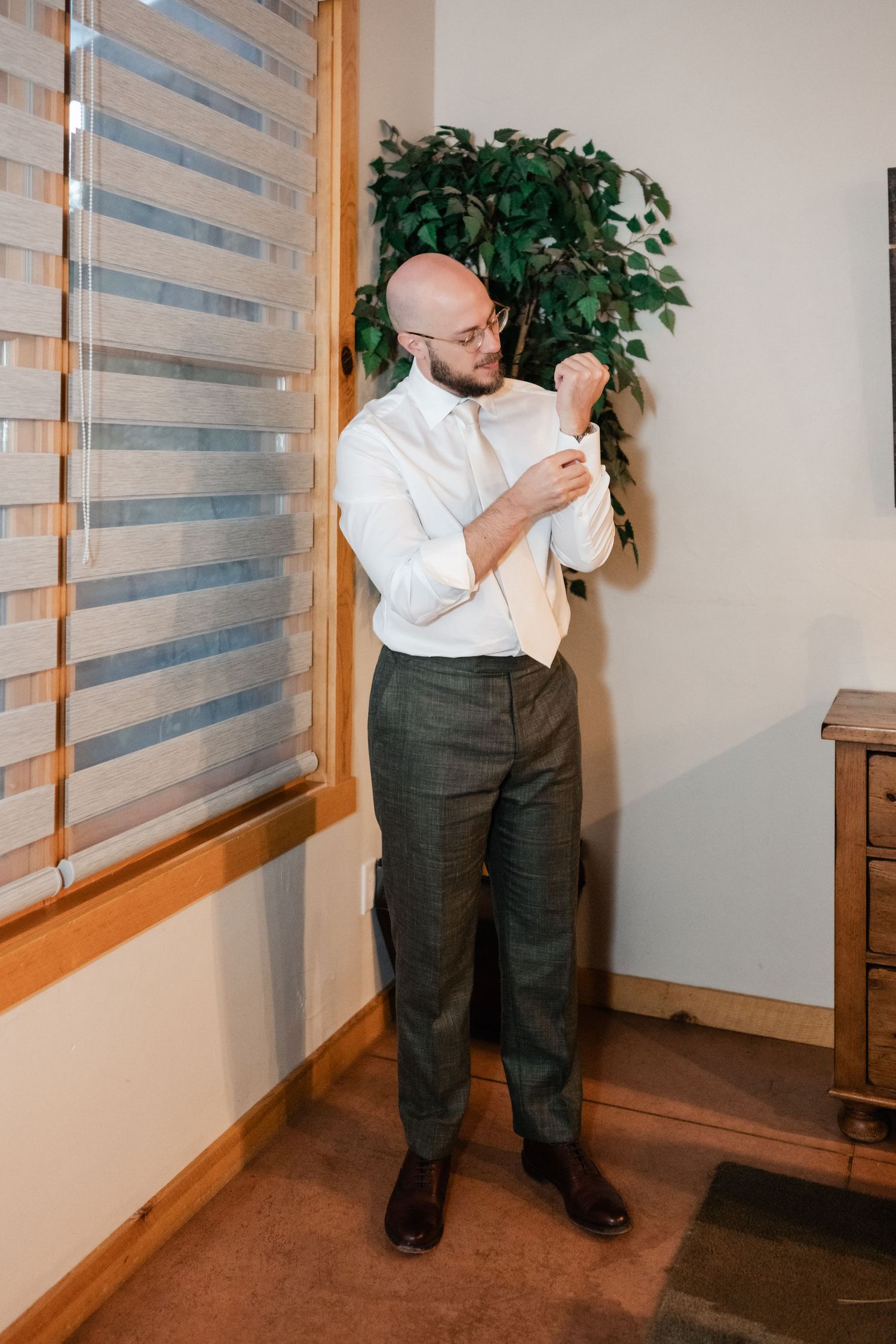 A sequence of photos showing someone adjusting their tie and getting dressed in formal attire.