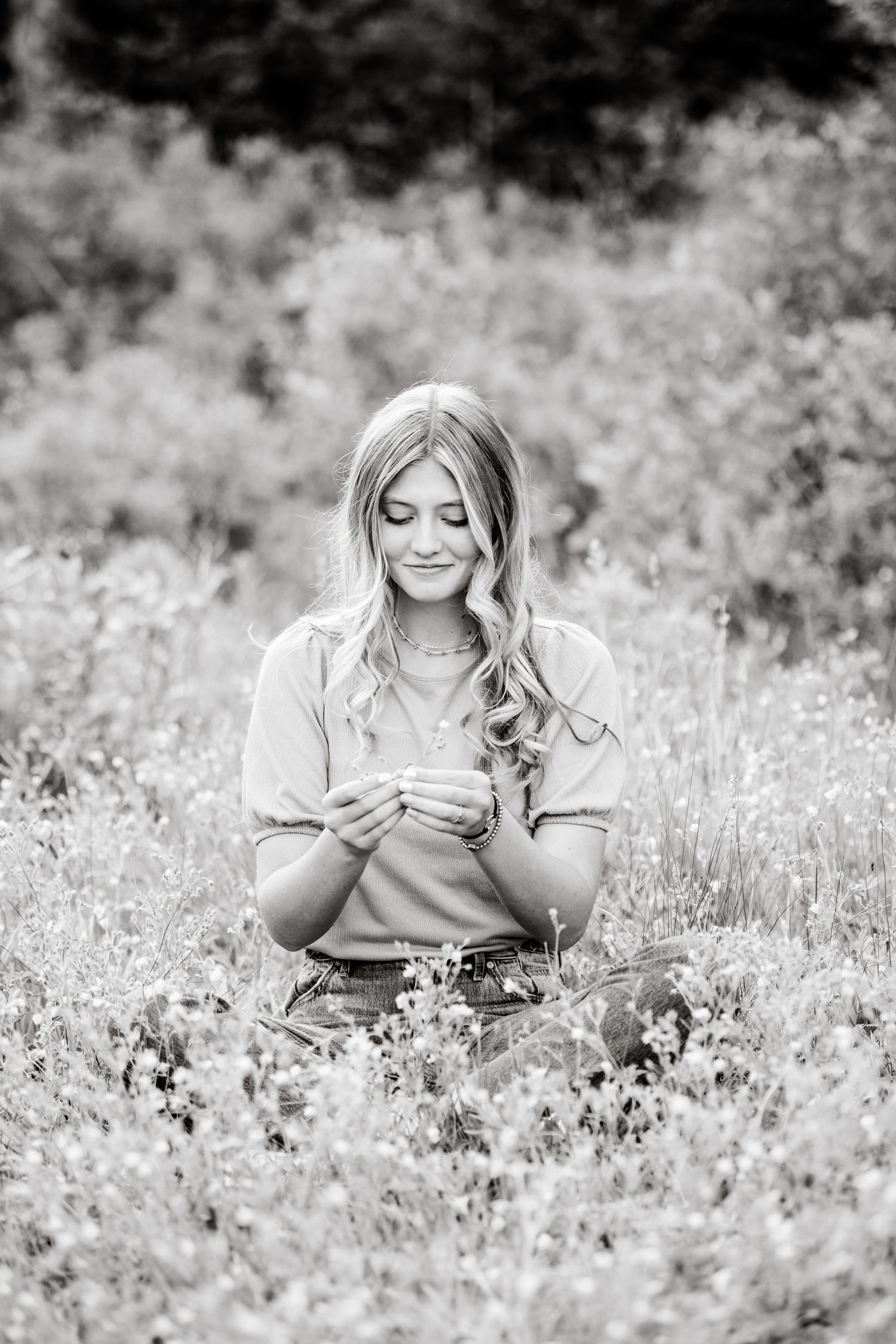 Black and white photo sequence of someone relaxing and posing in a field of tall grass and flowers.