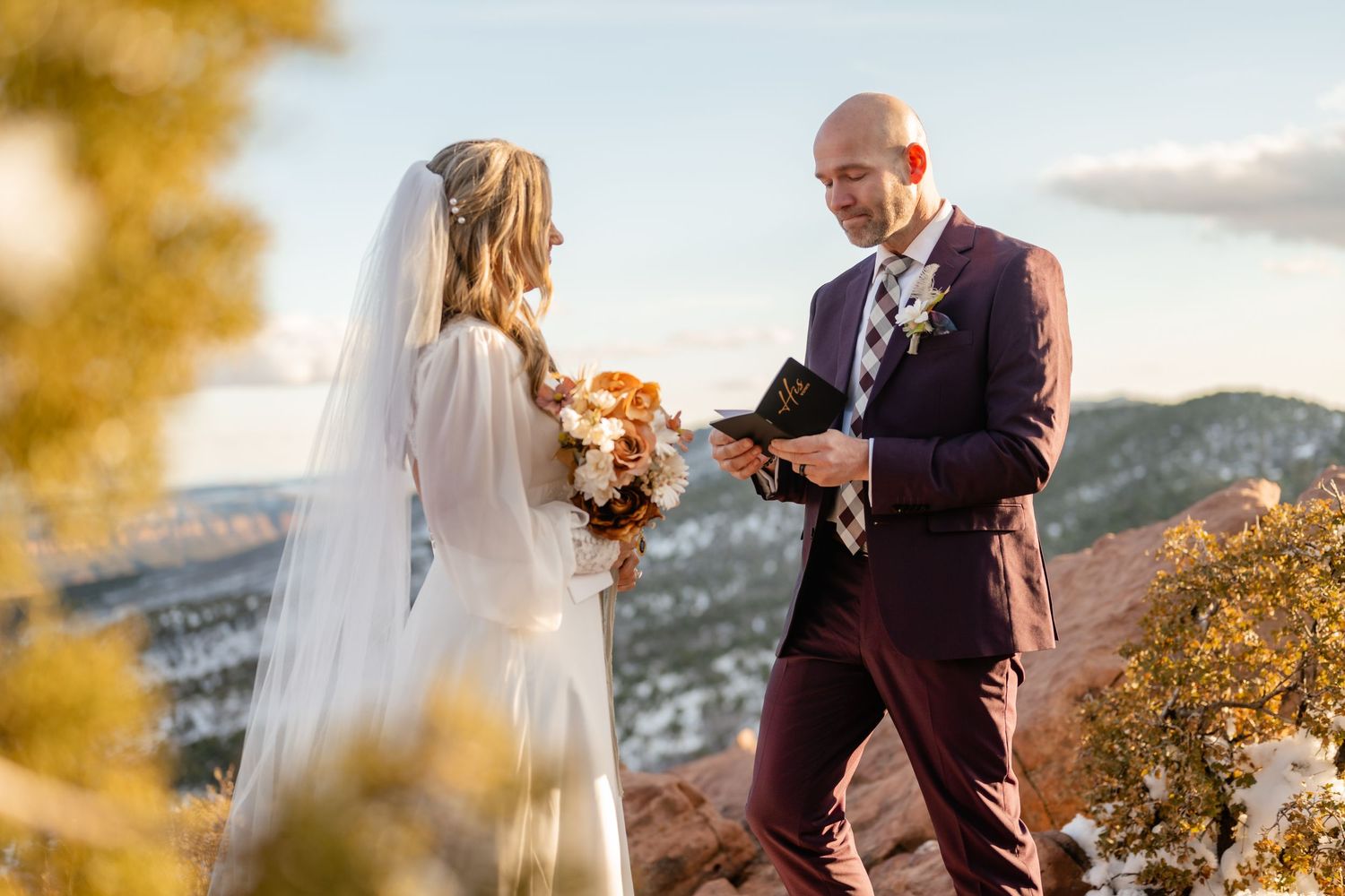 Sunset wedding portrait session with warm lighting against desert cliffs.