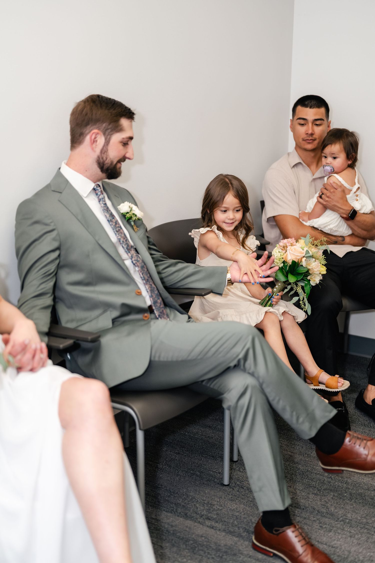 A sequence of photos shows a person in a gray suit sitting in a waiting room while holding a baby.