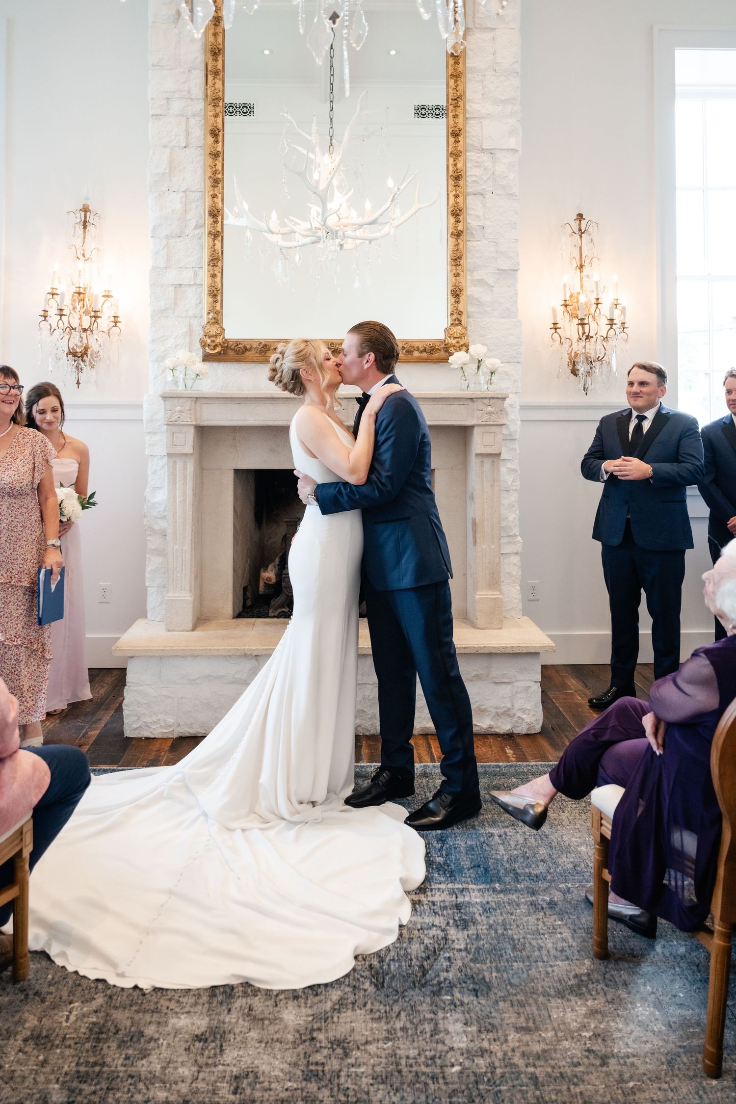 Wedding ceremony sequence in an elegant white chapel with chandeliers and decorative gold mirrors.