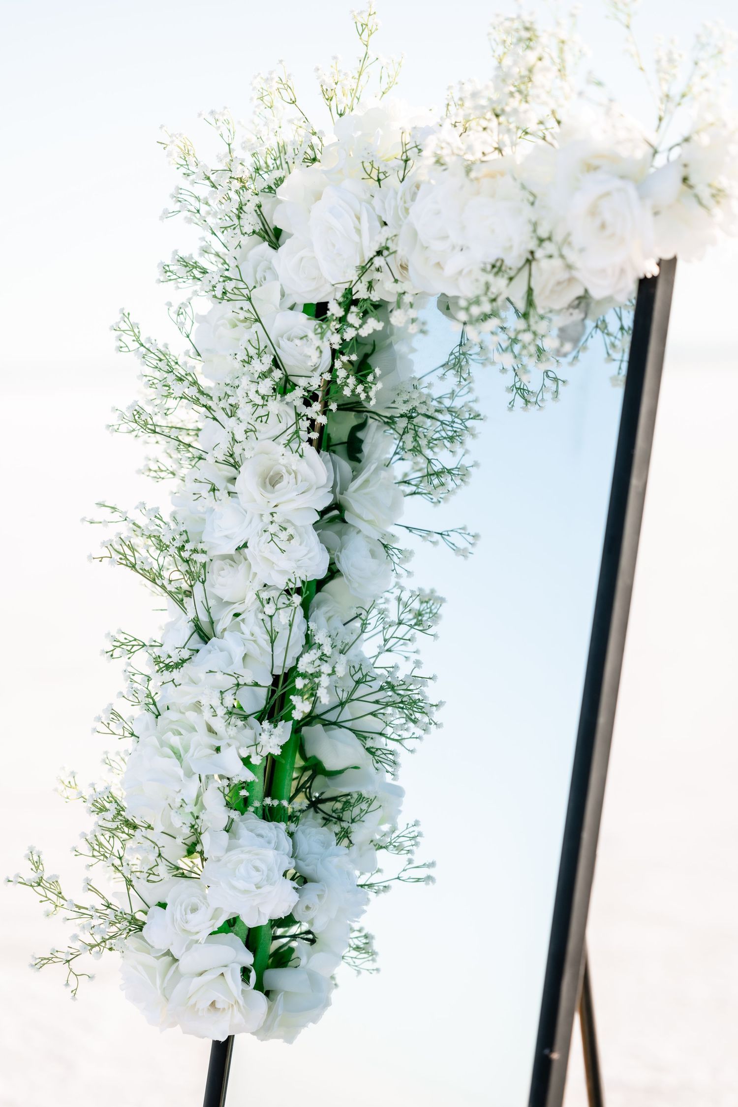 Close-up details of white floral arrangements with delicate baby's breath against a bright background.