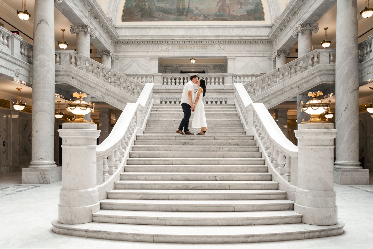 Elegant marble staircase with ornate columns and architectural details inside The Utah State Capitol Building. Utah Wedding Photographer.