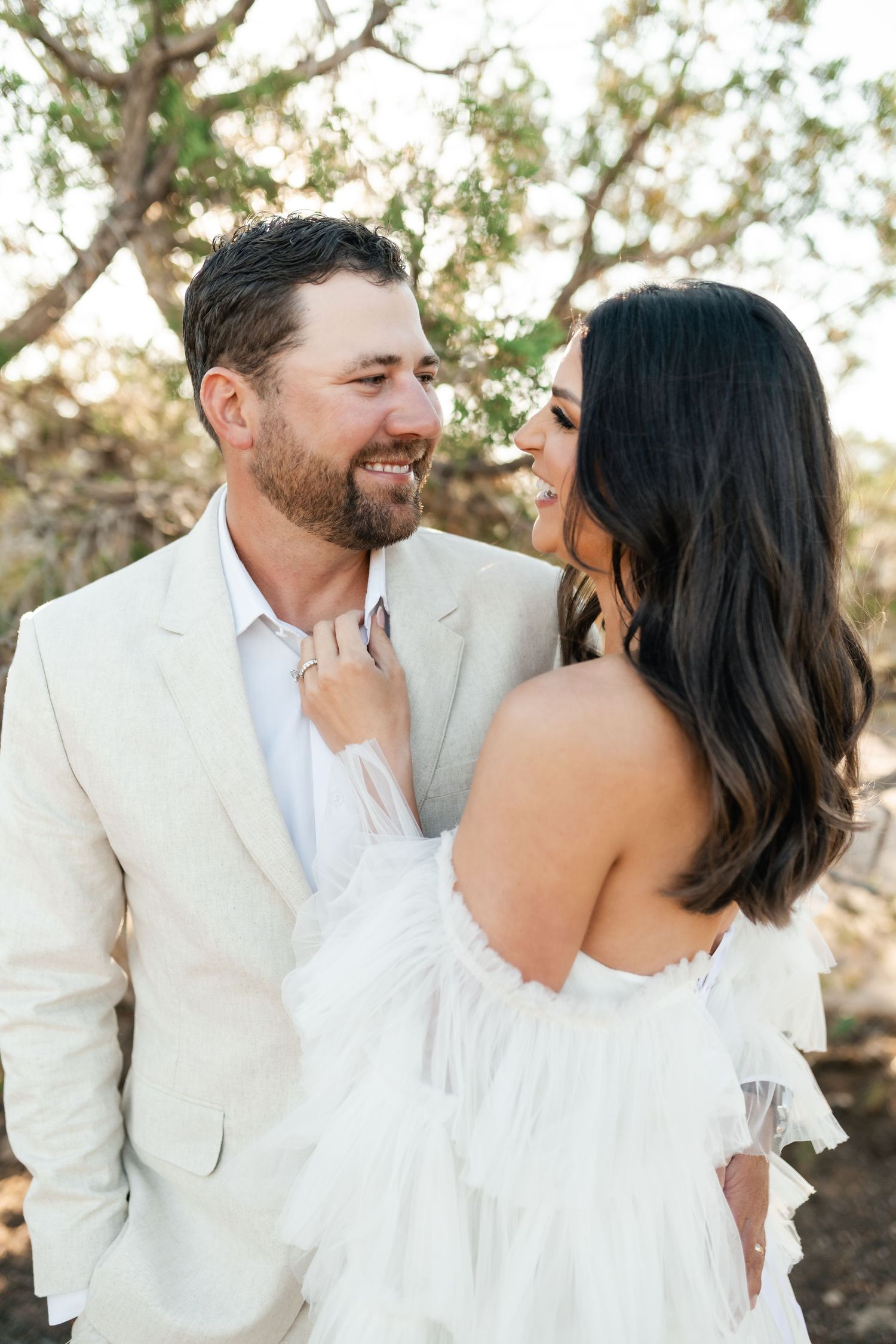 Zion destination photographer, A couple shares intimate moments in white wedding attire against a natural desert backdrop.