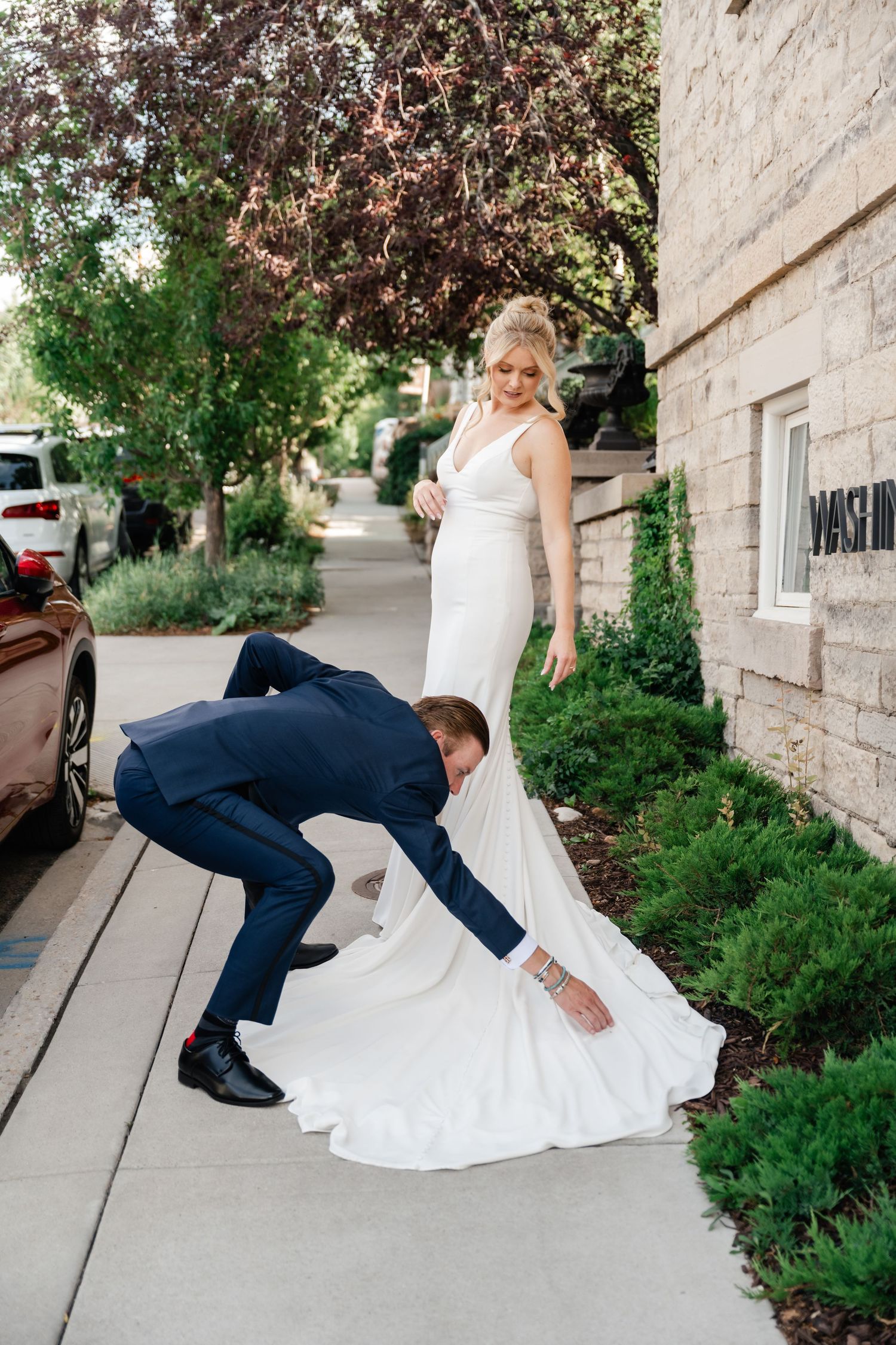 A sequence of playful wedding photos showing the couple falling down dramatically on stone steps surrounded by greenery.