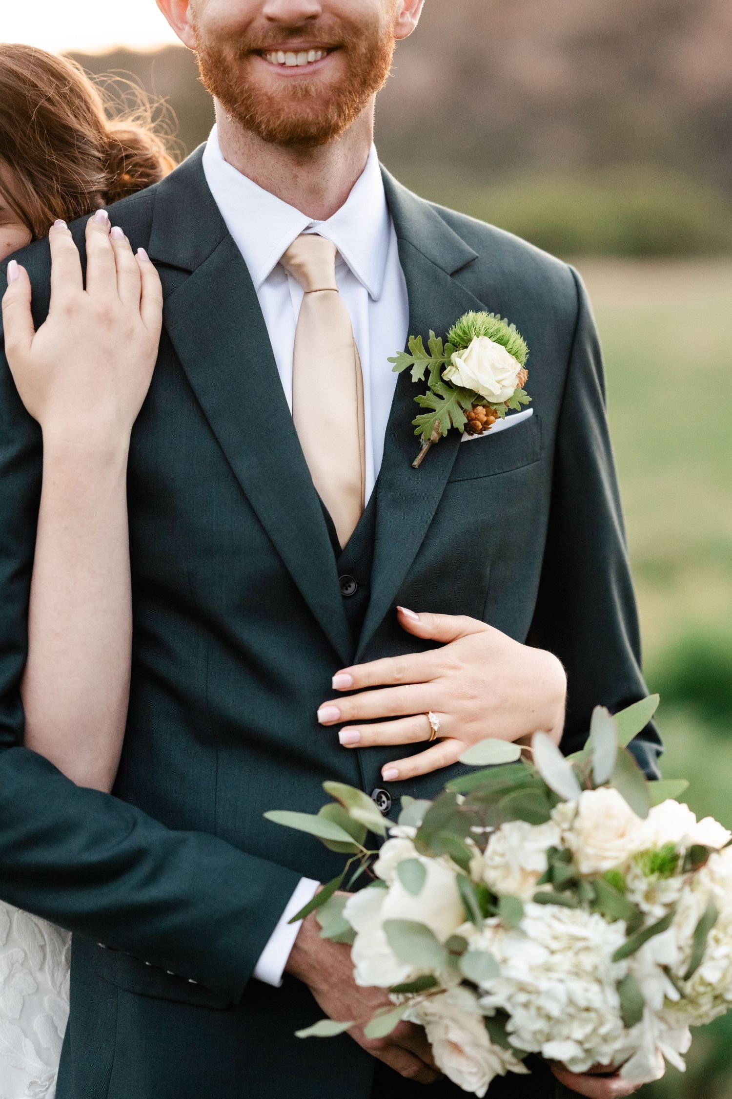 Elegant wedding details showing formal suit, white flowers, and gentle embraces.
