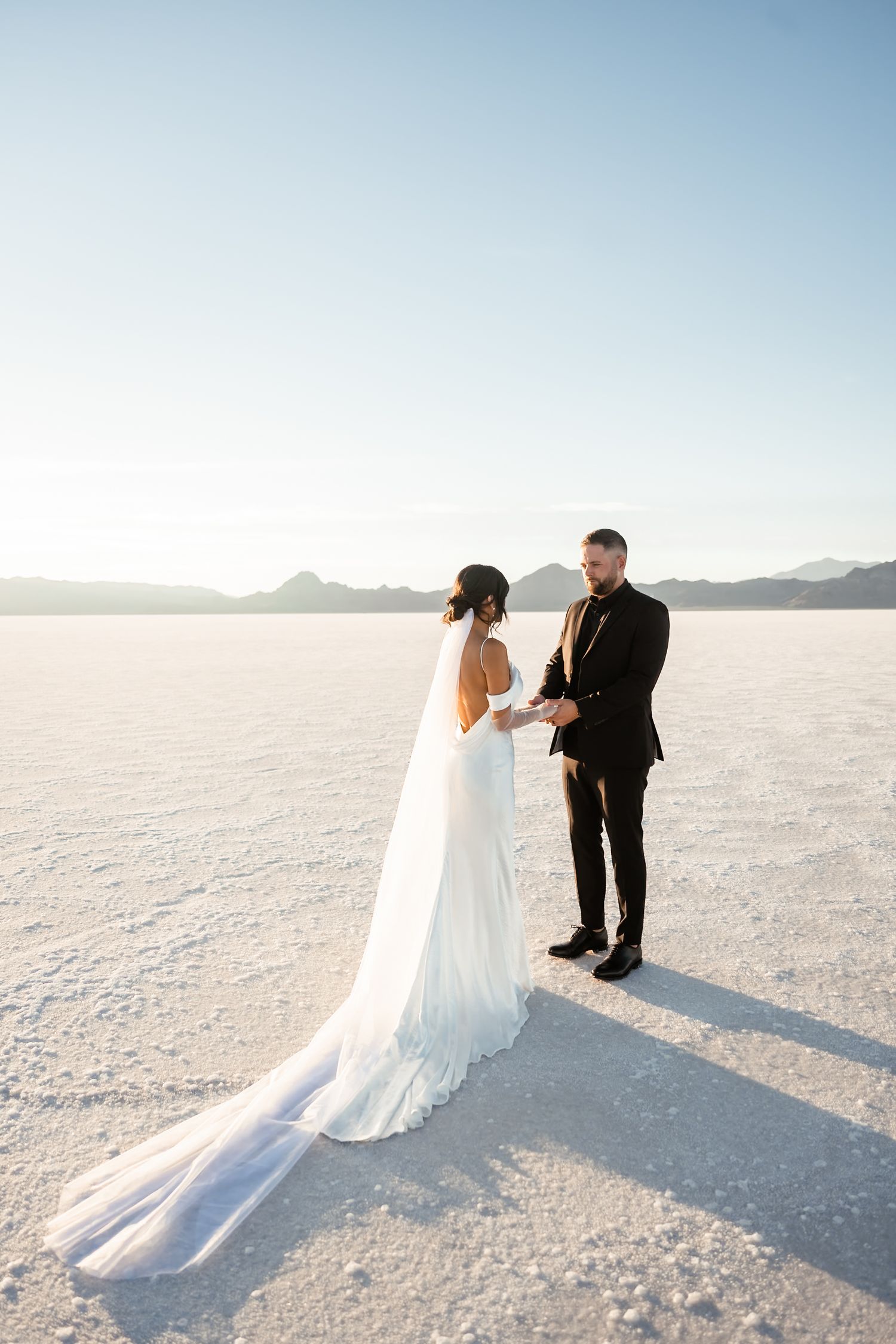 Romantic wedding photography session on pristine white salt flats at golden hour.