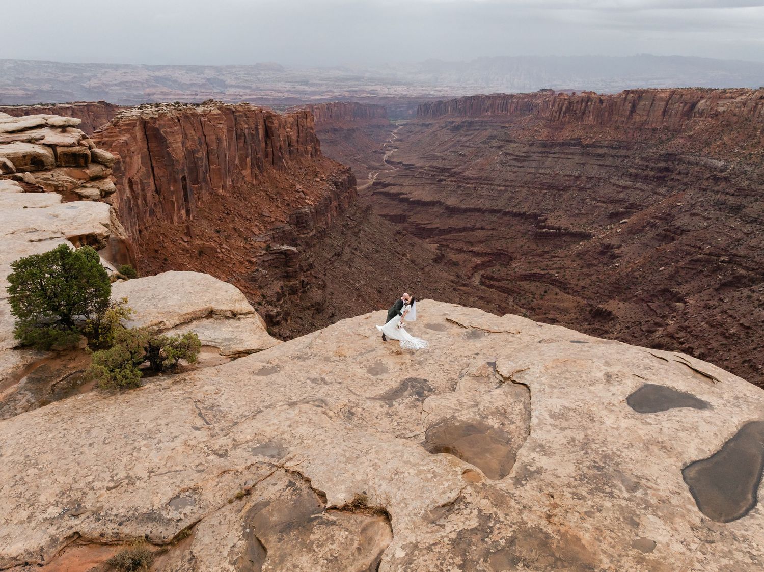 A panoramic view of deep red canyons and towering cliffs at Dead Horse Point State Park in Utah during sunset.