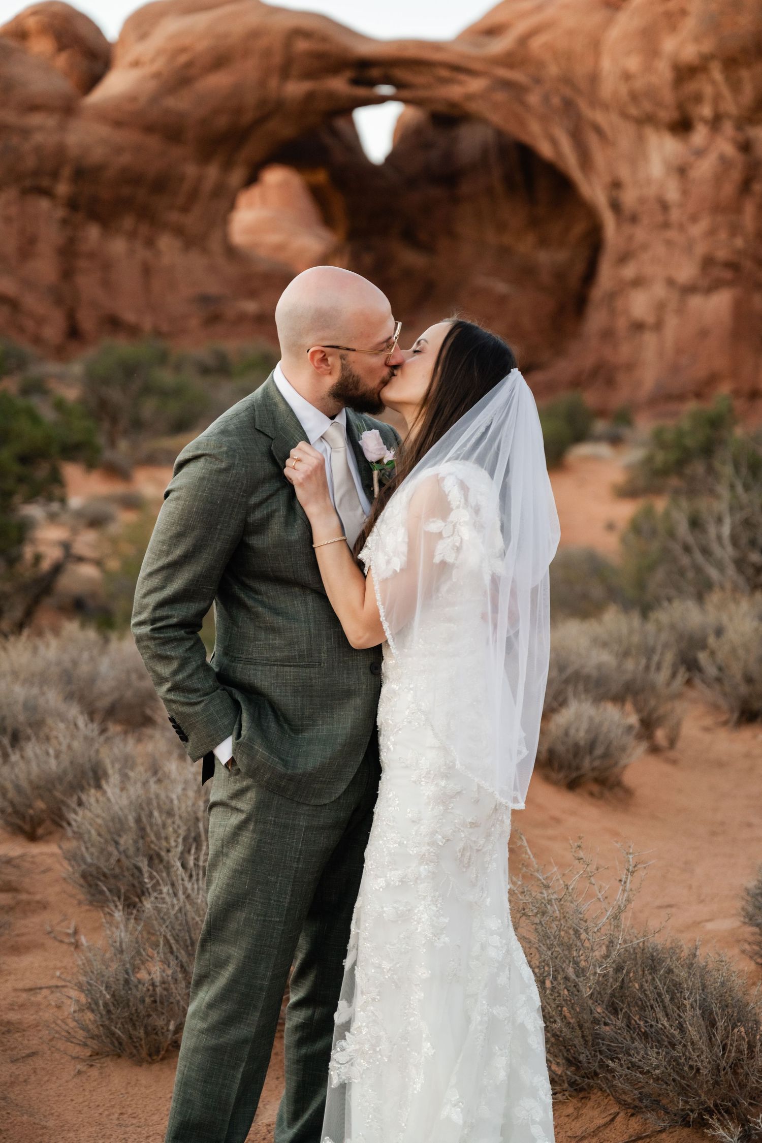 Romantic wedding moment under Double Arch in Arches National Park.