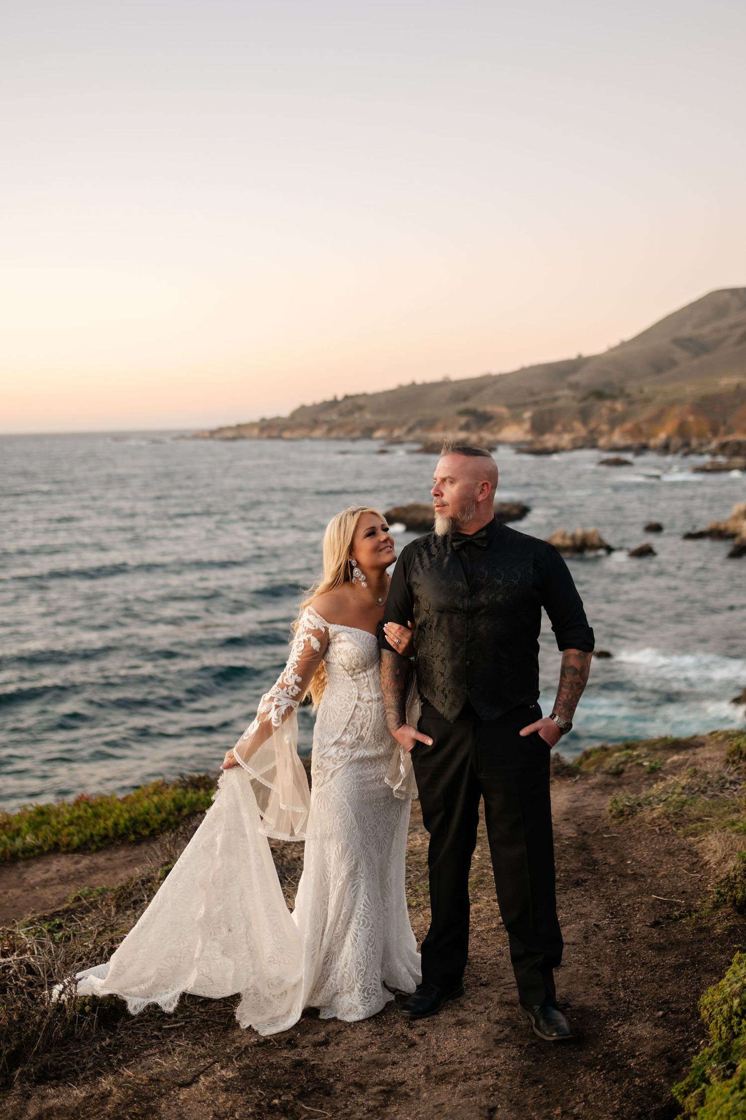A romantic coastal photoshoot with a dramatic ocean backdrop at sunset.