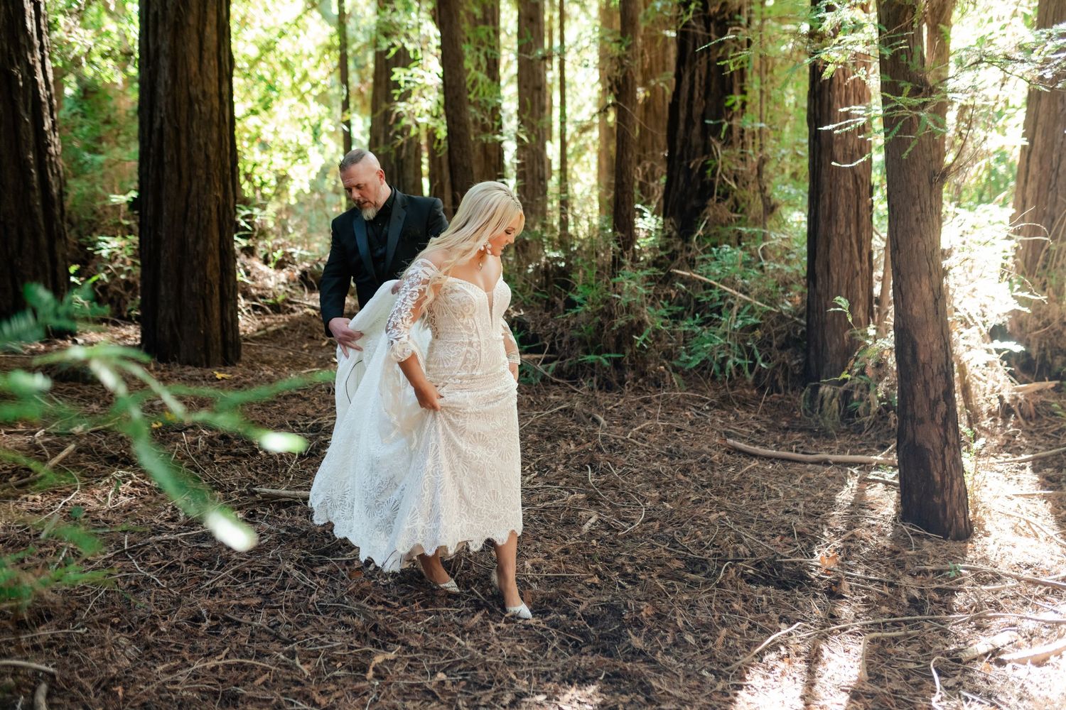 Wedding couple walking through a serene redwood forest.