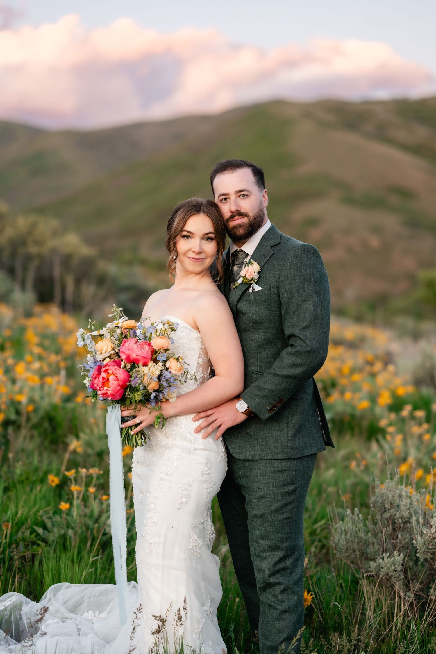 Wedding portrait with couple surrounded by mountain wildflowers at golden hour.