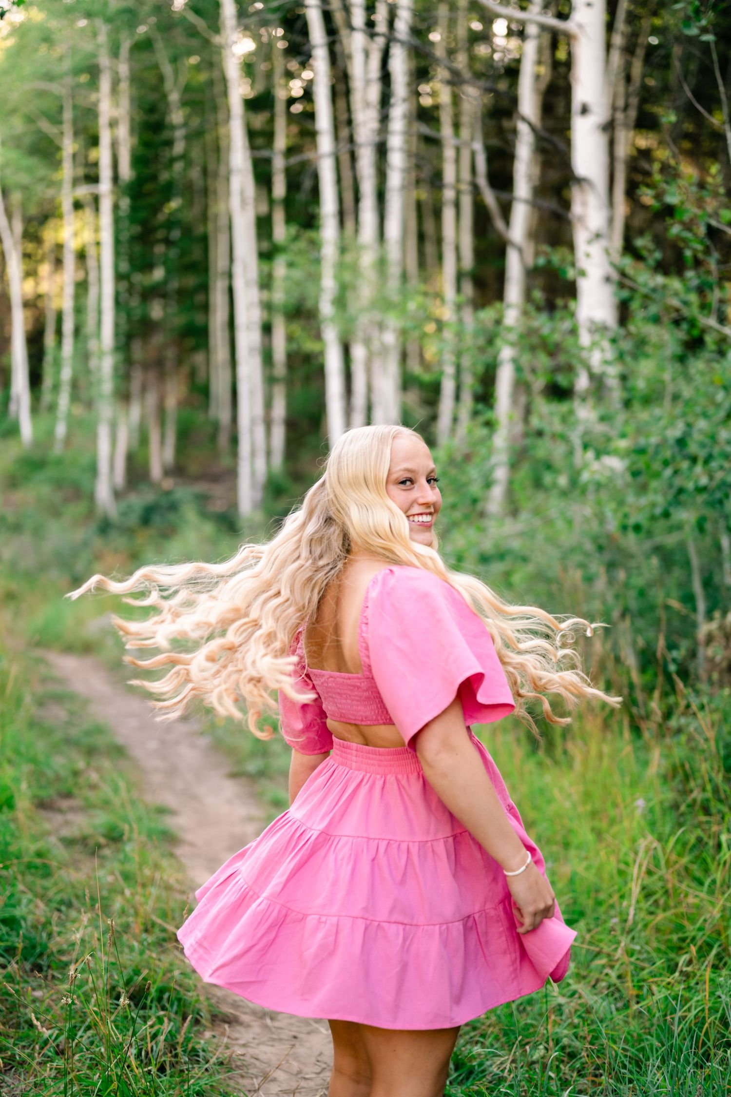 girl twirling in a hot pink dress during her mountain senior session