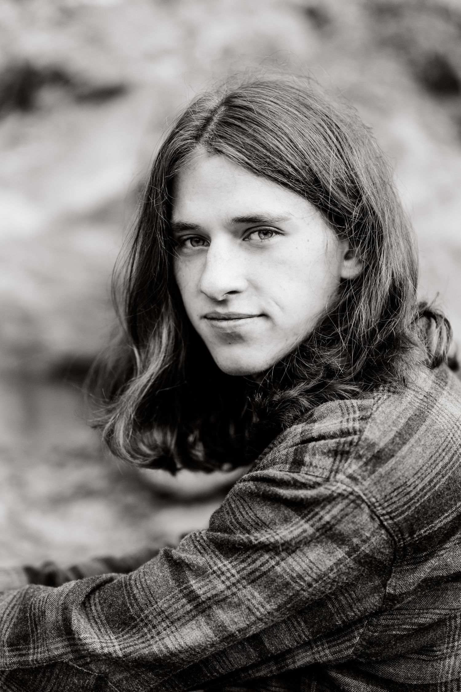 A series of black and white portraits showing someone wearing a plaid scarf looking to the side with different expressions.