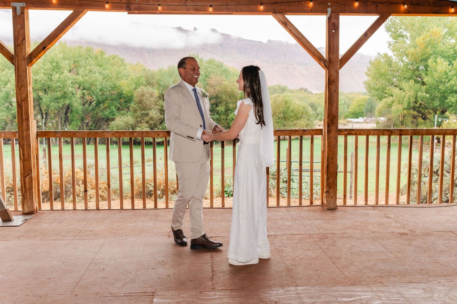 Covered outdoor pavilion with mountain views and guests gathering for an event.