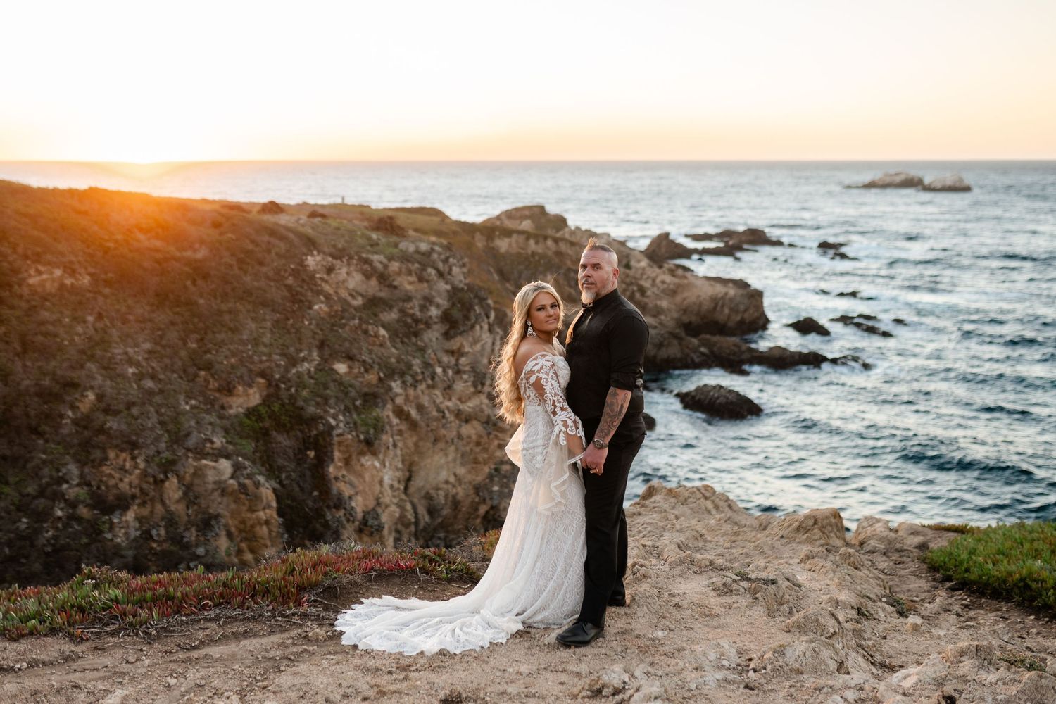 A sunset wedding portrait on California's dramatic coastal cliffs.