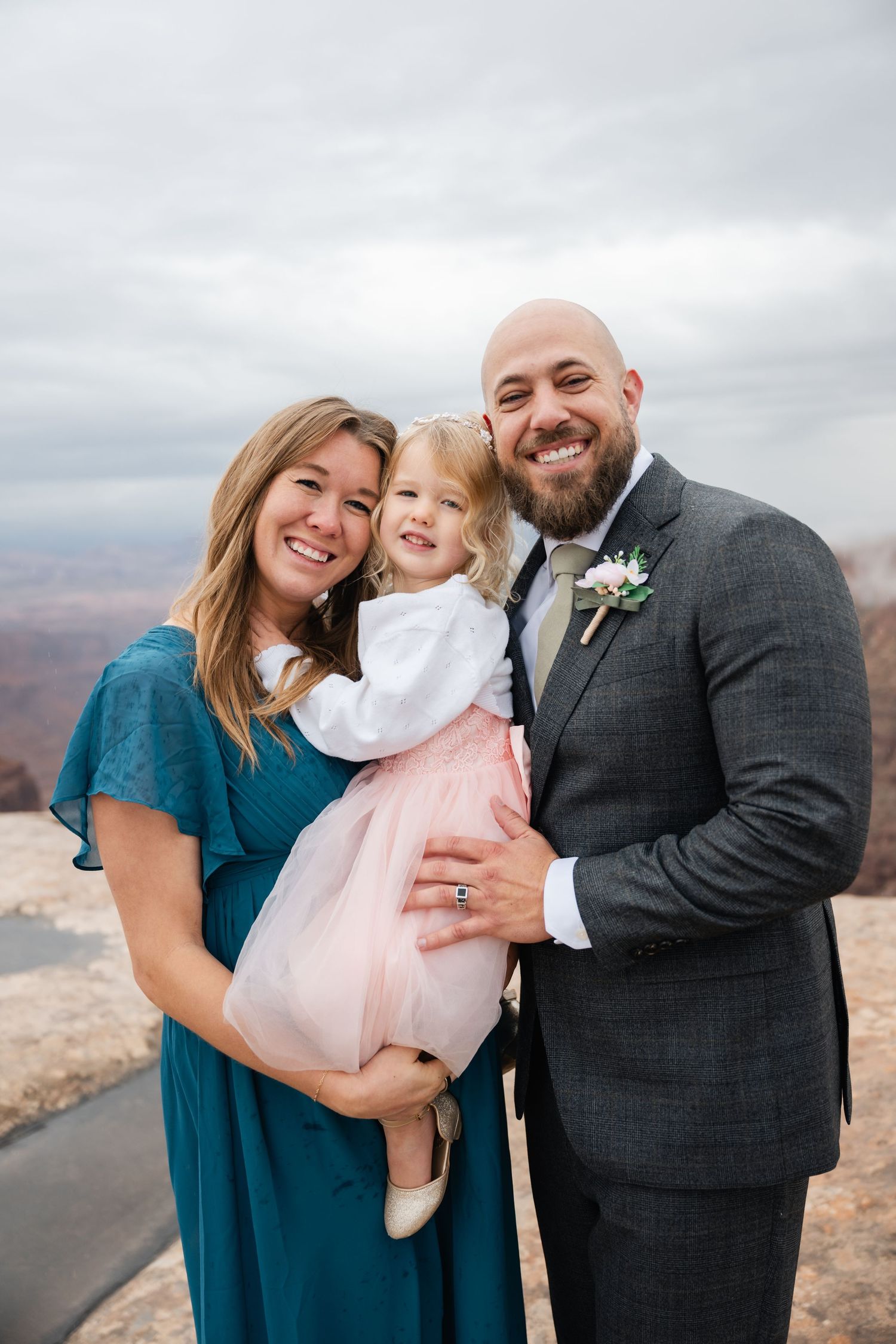 Family portraits captured against dramatic canyon backdrop in teal and formal attire.