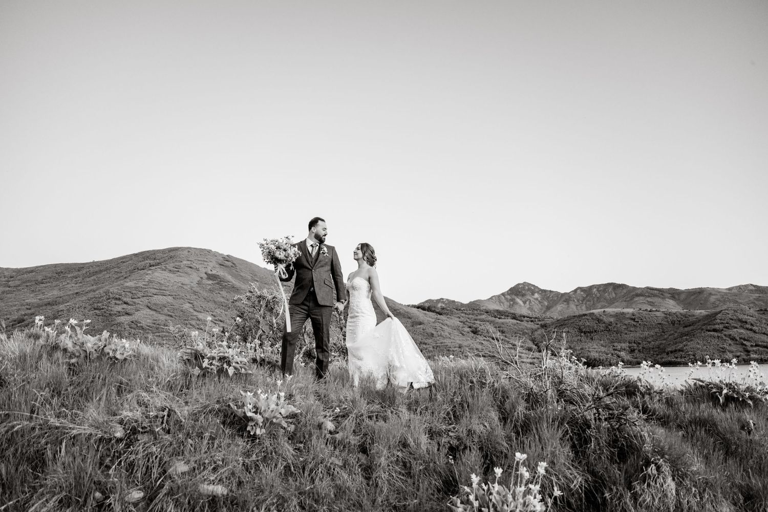 Black and white panoramic wedding photos showing a couple against rolling mountain landscapes.